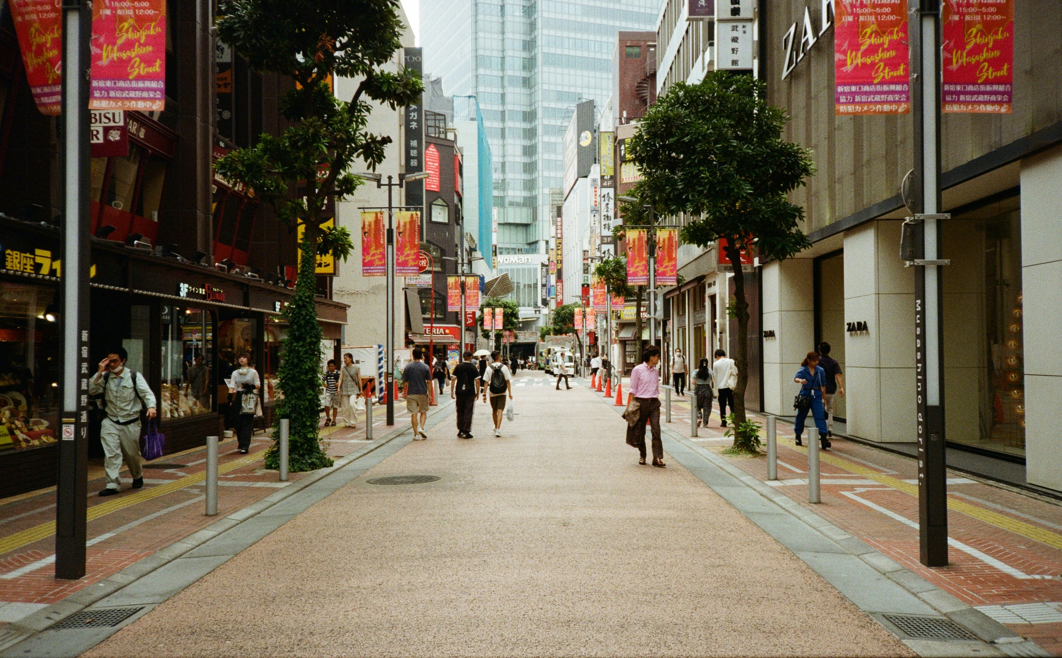 People stroll down a busy street in a city.