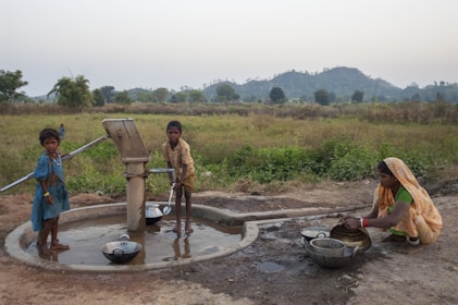 People draw water from a well in a rural area.