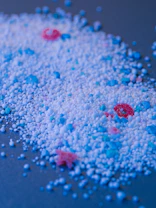 Colored granular substance is scattered on a surface.