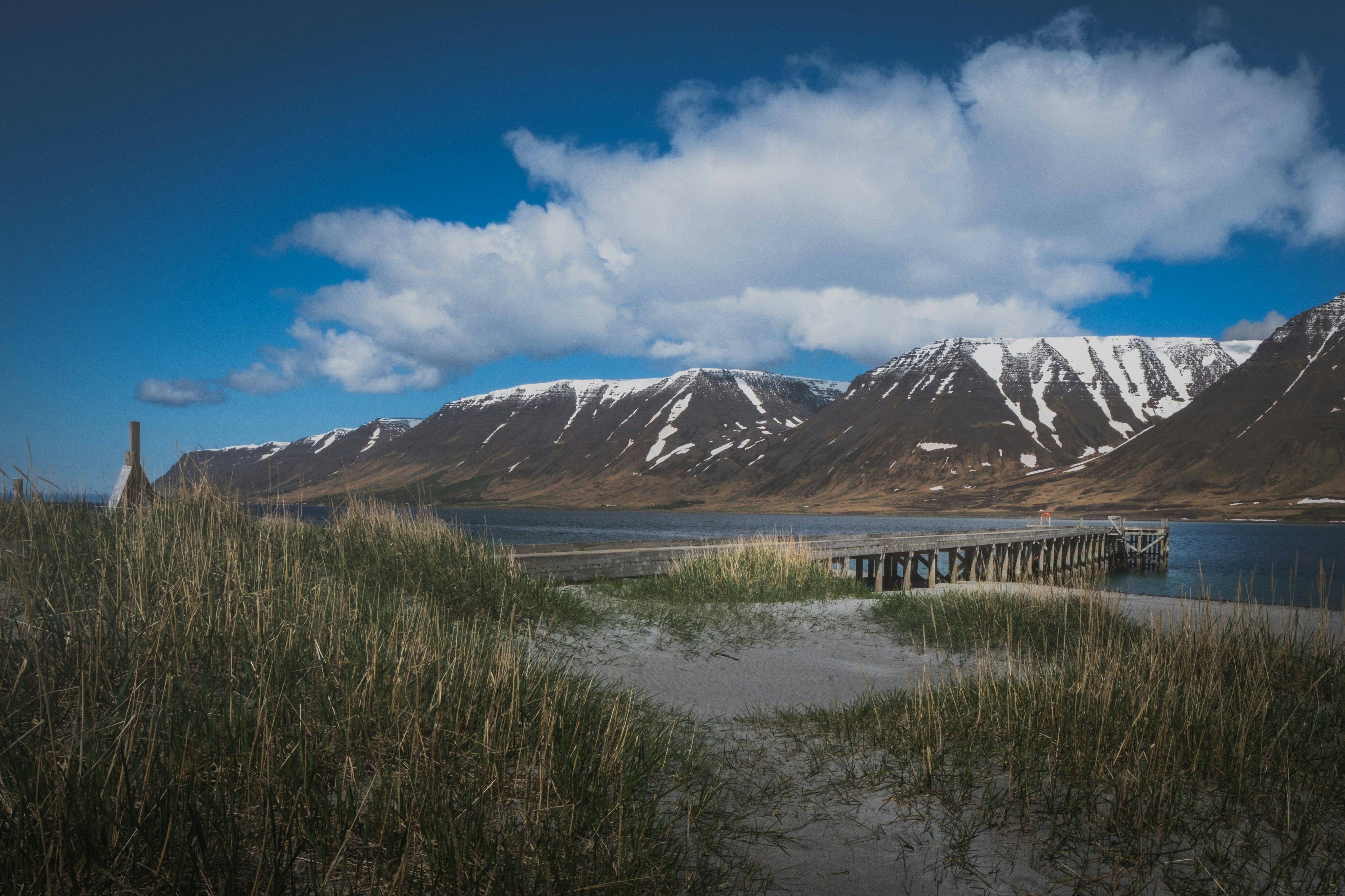 Mountains overlook a coastal landscape under a blue sky.