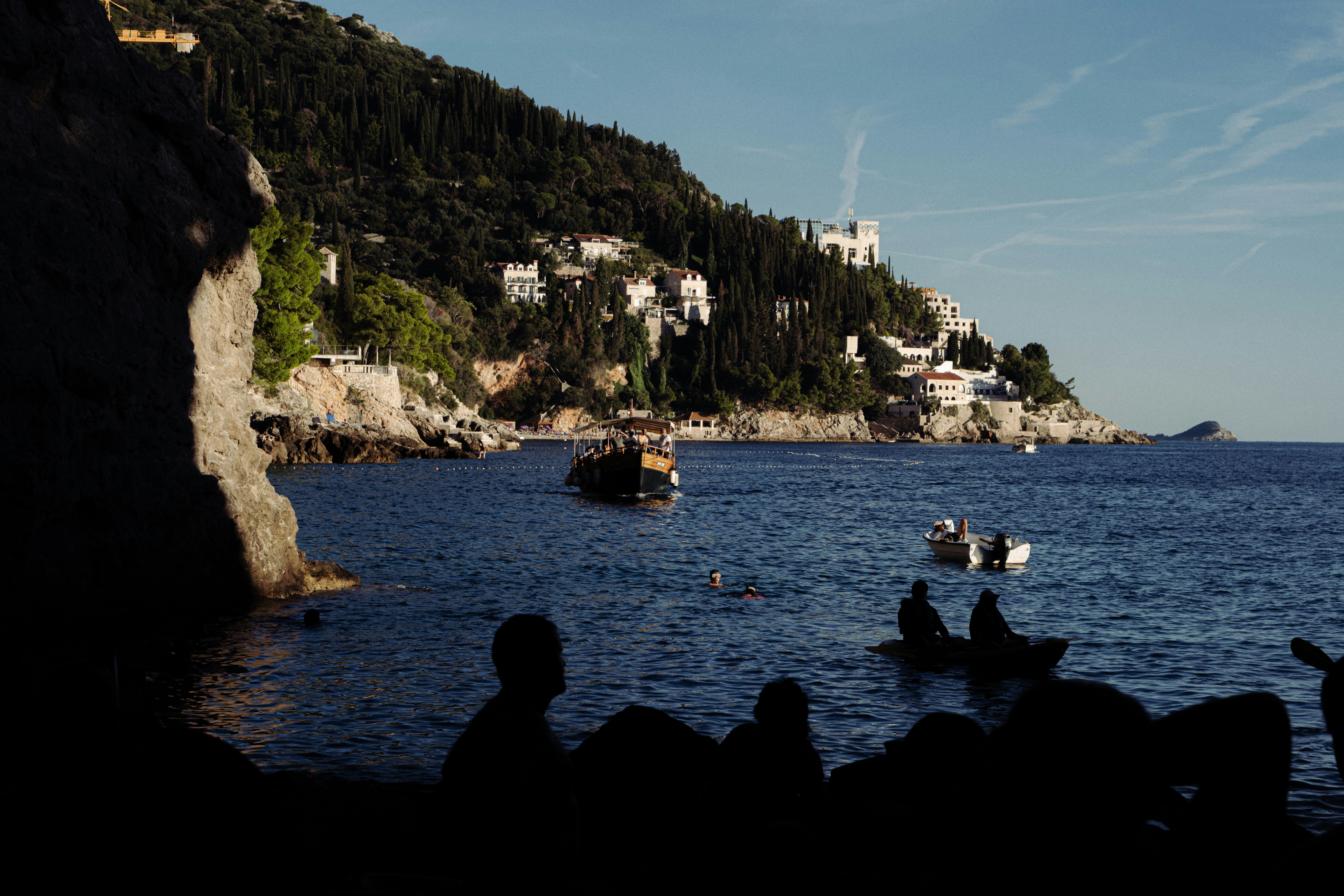 Coastal view with boats and hillside buildings.