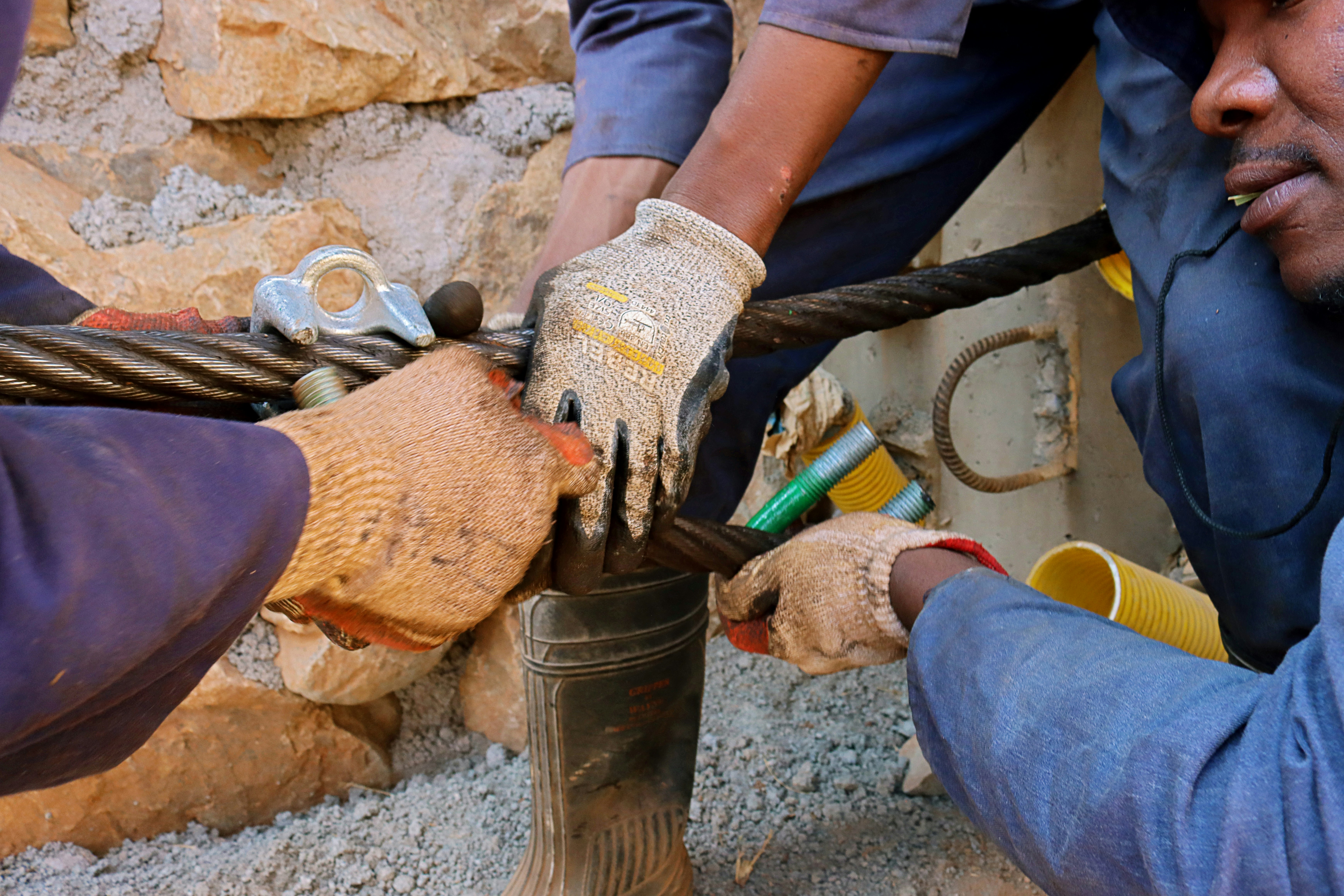 Workers connecting cables with specialized equipment, symbolizing local development and employment.