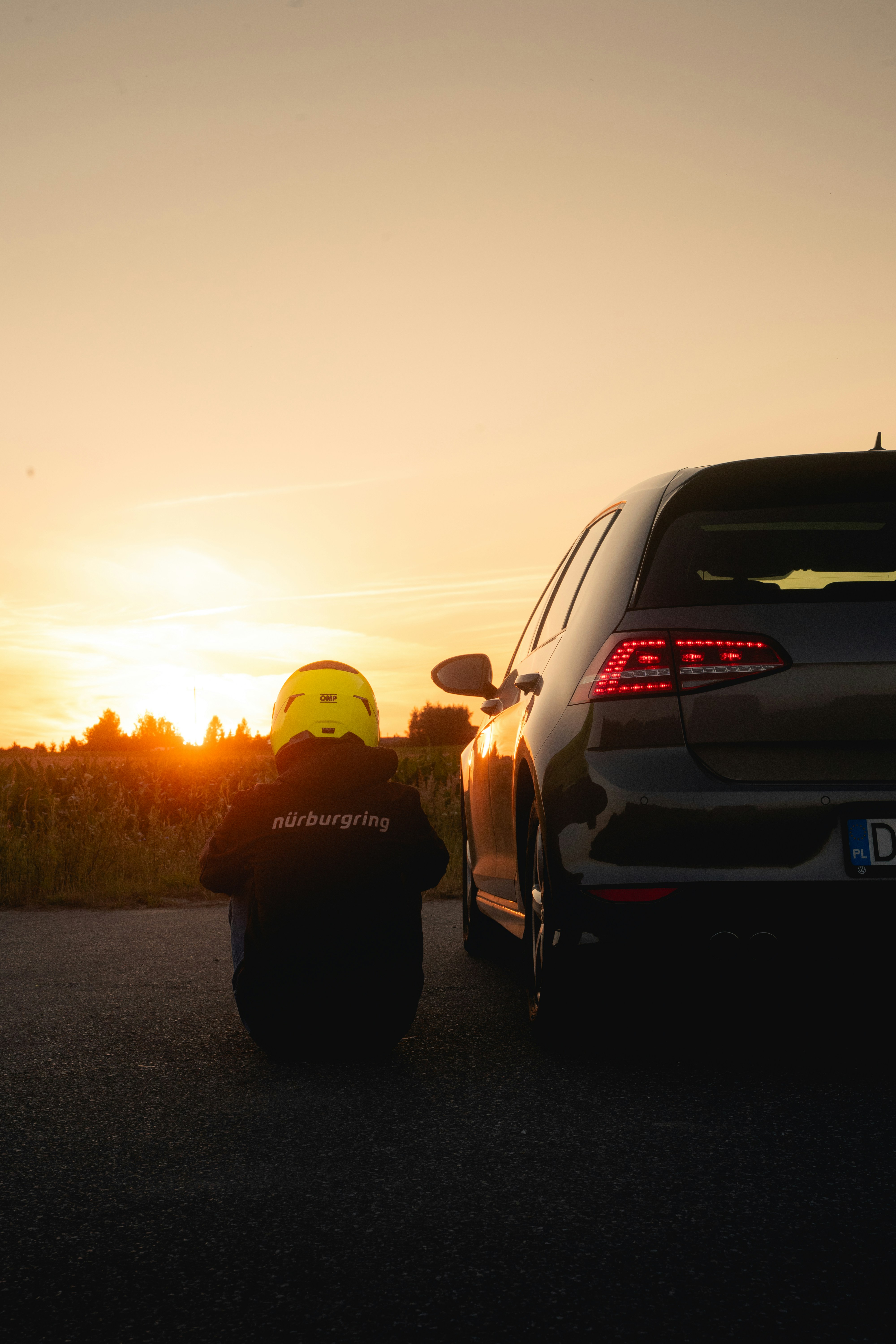 Der Fahrer beobachtet den Sonnenuntergang neben seinem Auto.