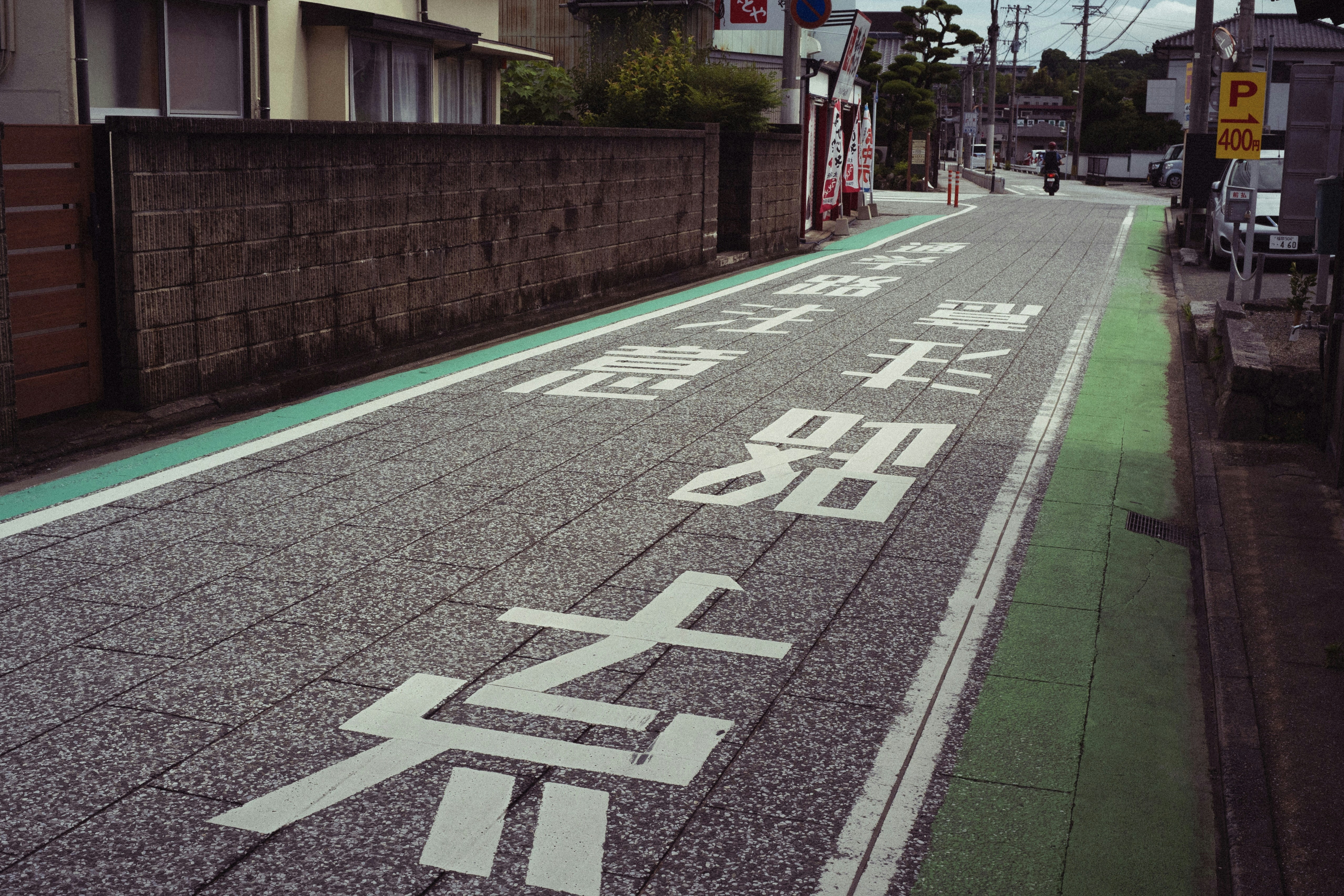 Green rectangular sign for '避難所' (Hinanjo) outside a community center in Japan