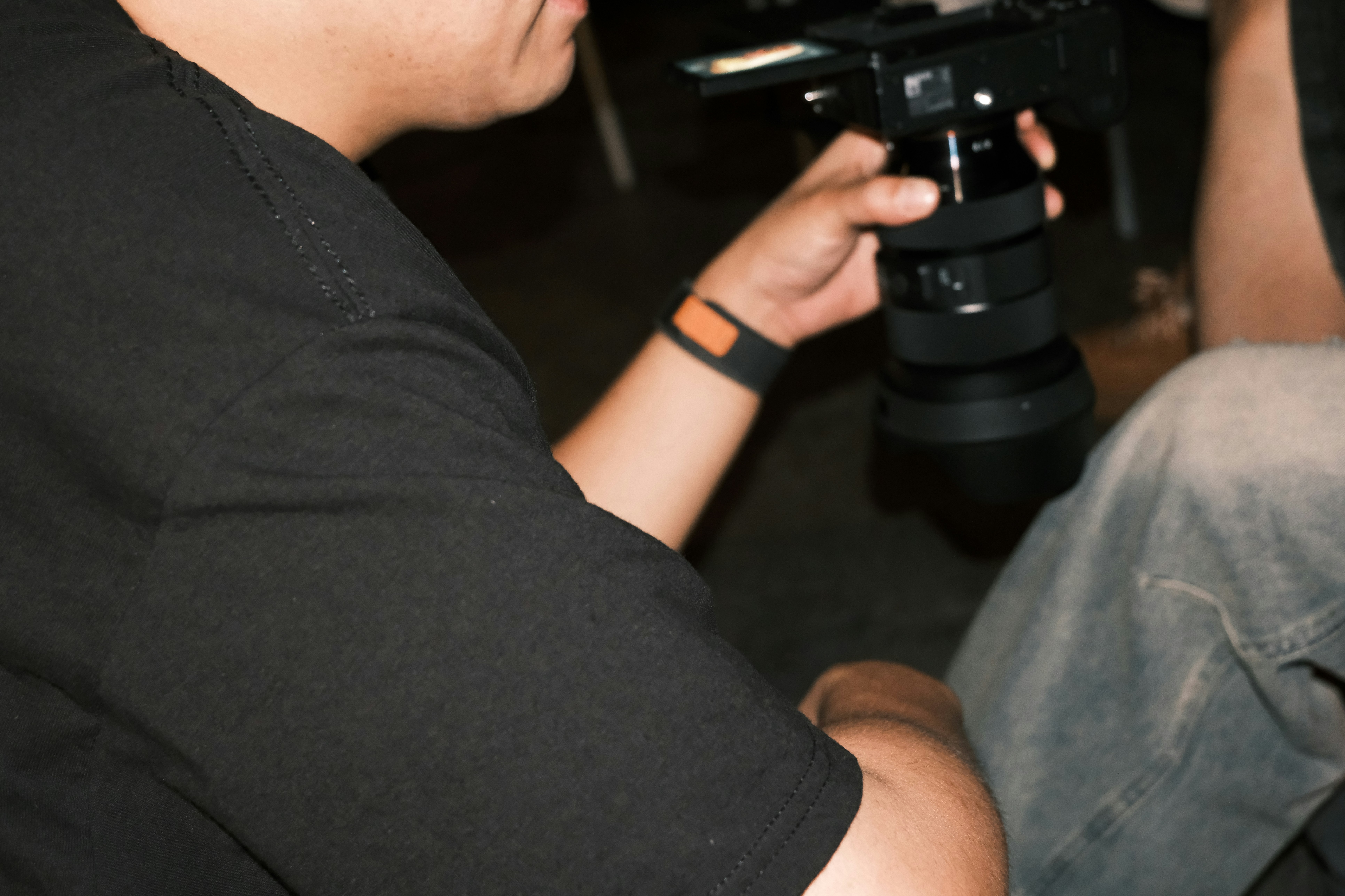A person is holding a camera with a large lens.
