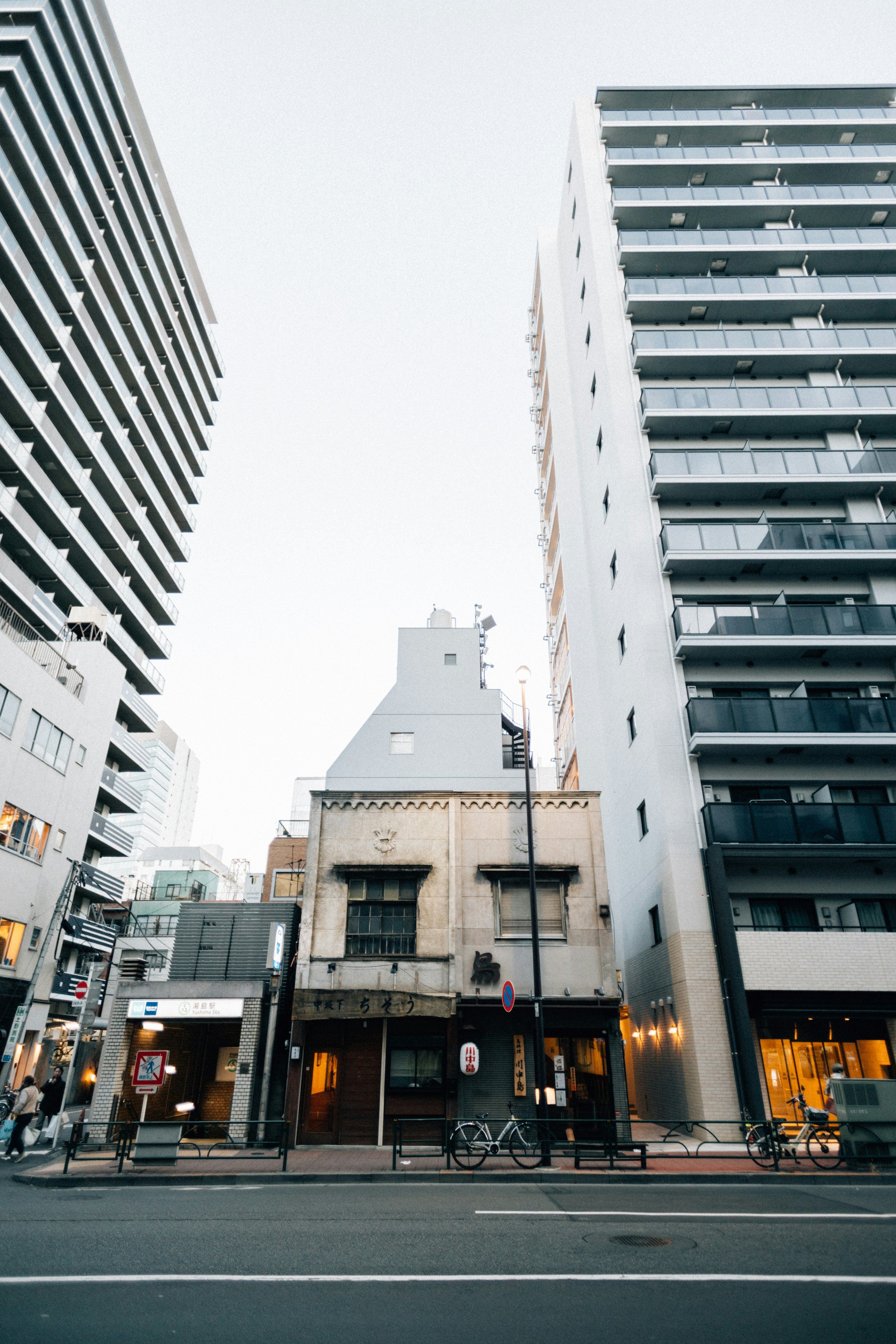 古い建物は、背の高いモダンな建物の間に佇んでいます。