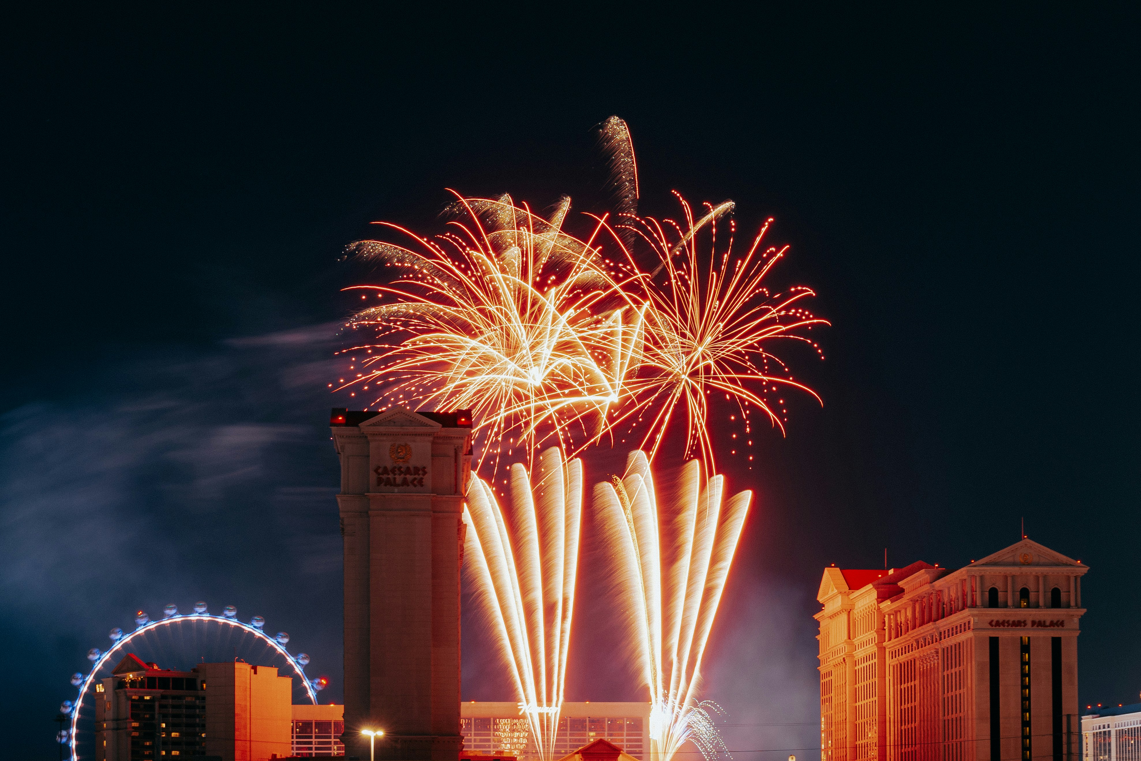 Fireworks explode above city buildings at night
