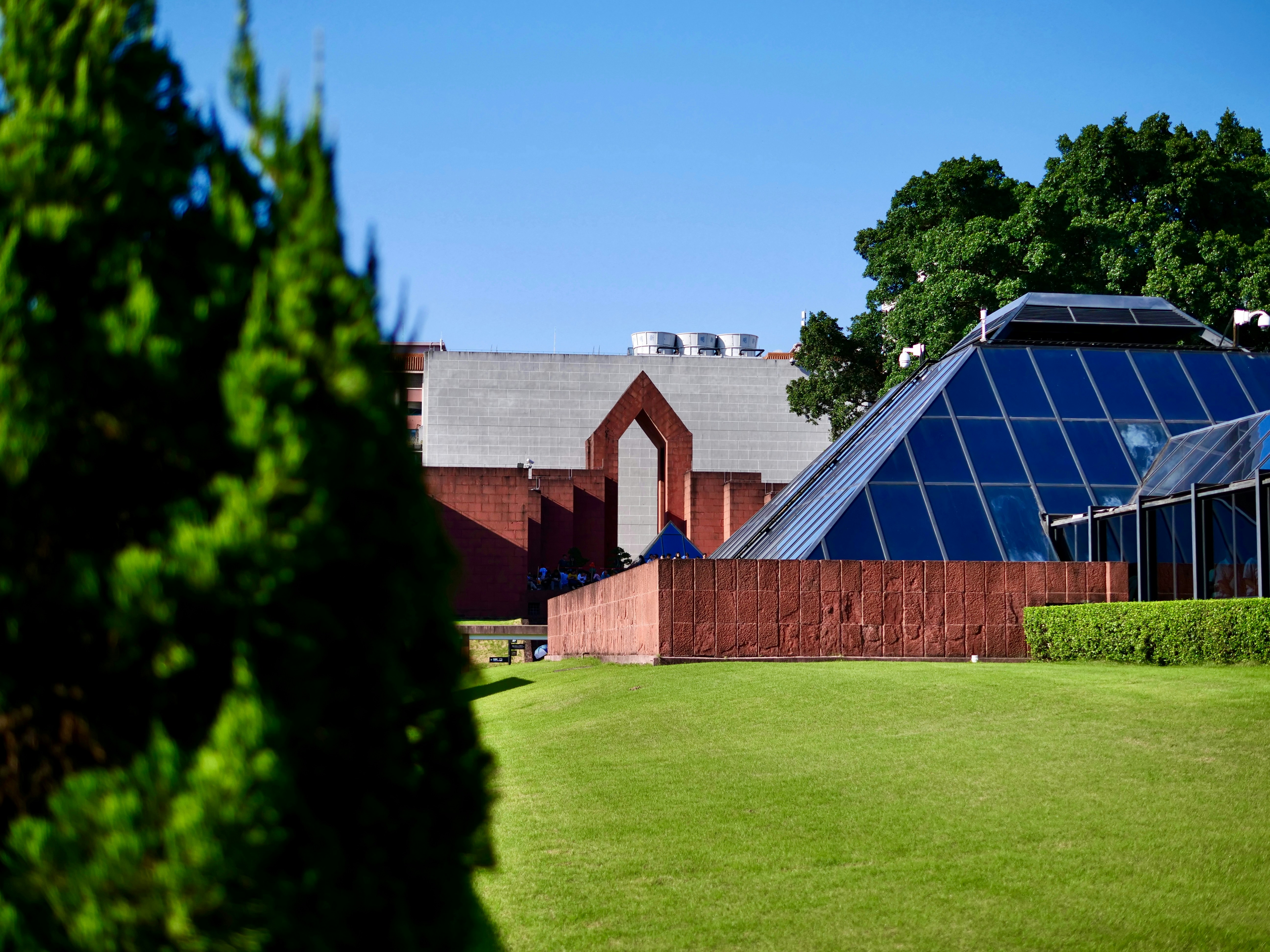 Buildings with a pyramid and green lawn are shown.