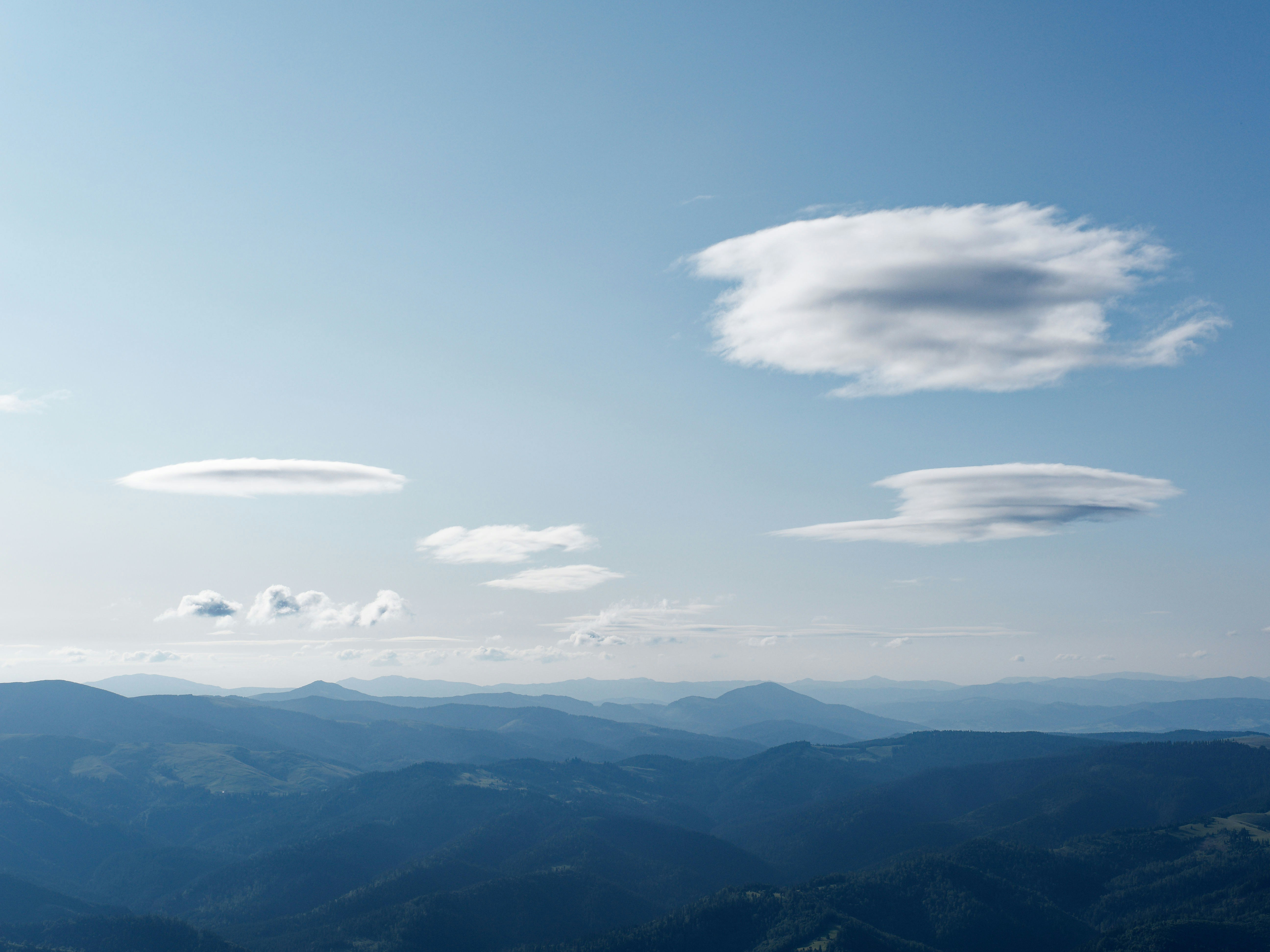 Clouds float above rolling hills and mountains.