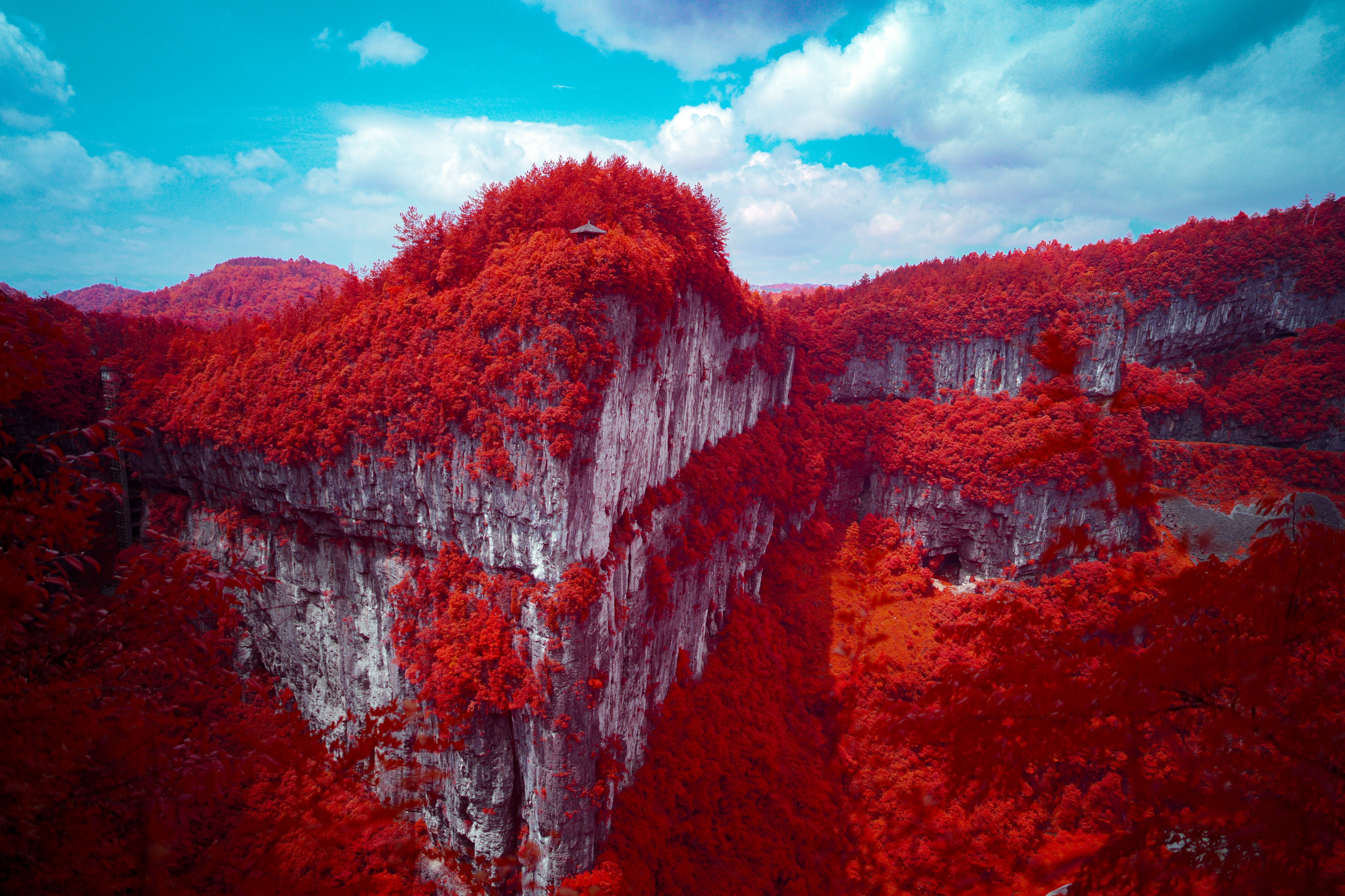 Red mountains and cliffs under a blue sky.