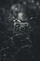 A vintage camera sits in a dark, moody setting.