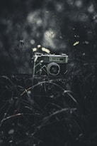 A vintage camera sits in a dark, moody setting.