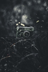 A vintage camera sits in a dark, moody setting.