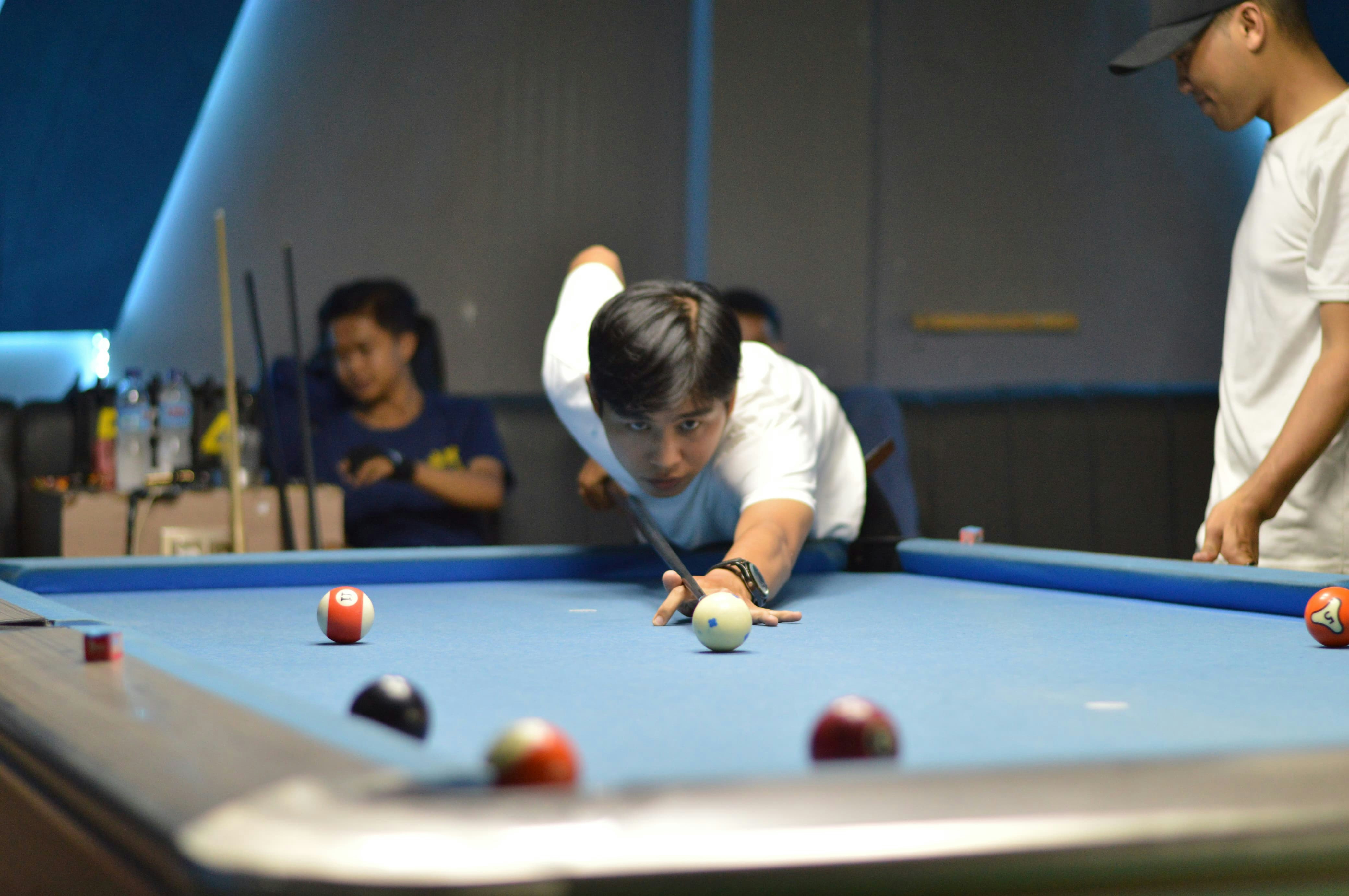 A man prepares to shoot a pool ball.