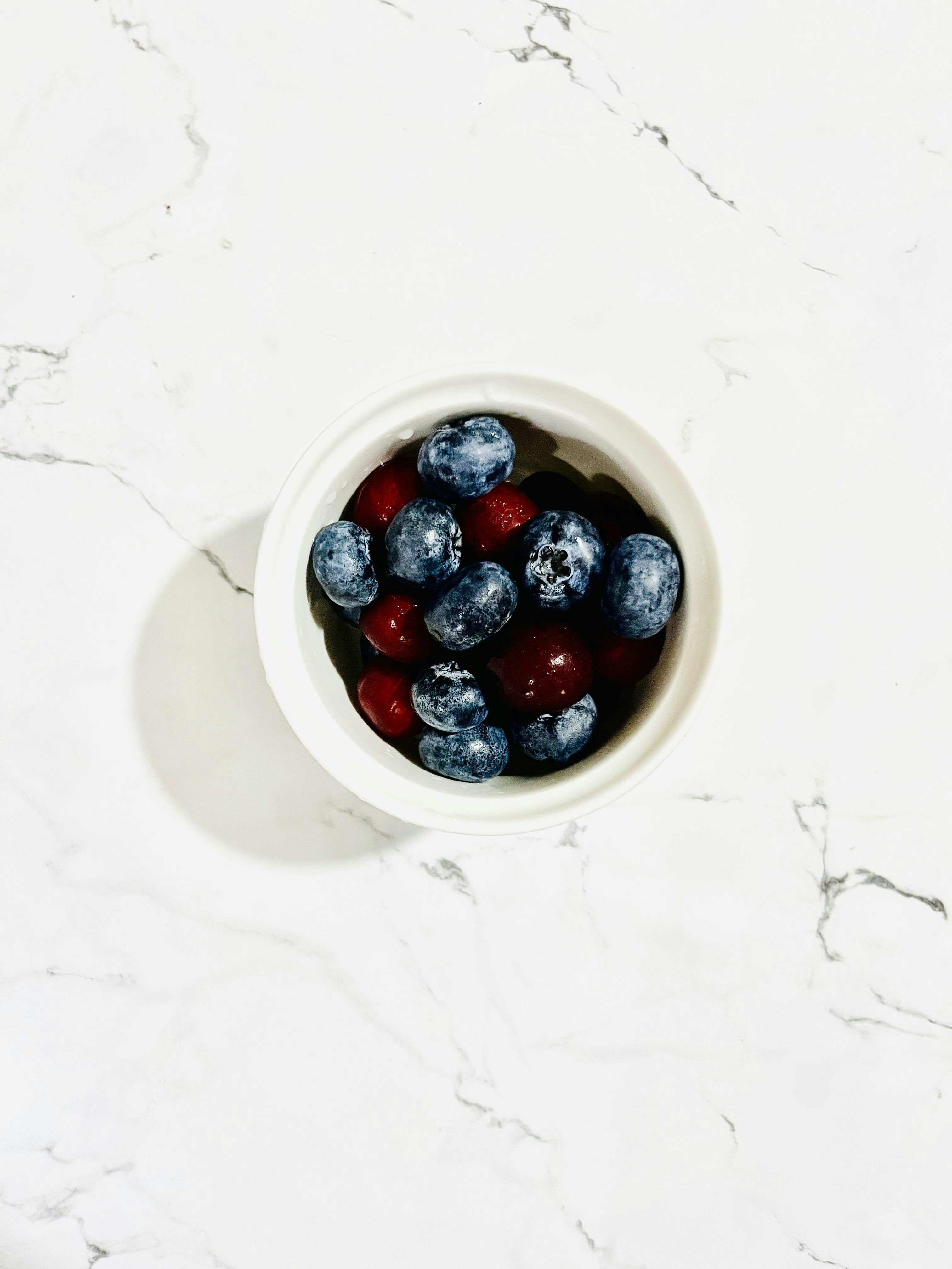 A bowl of Greek yogurt with fresh berries and honey
