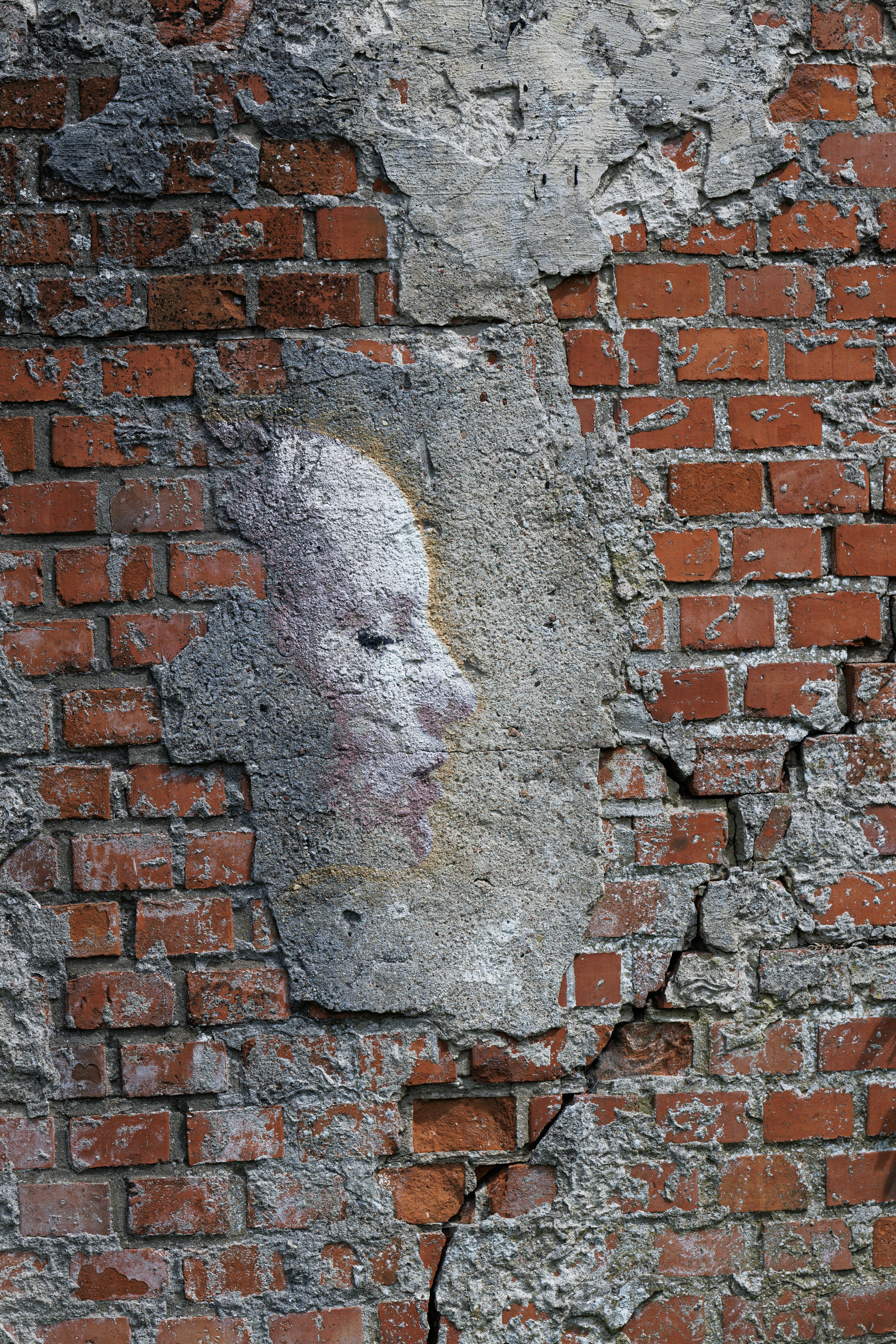 A brick wall with a face painted on it.