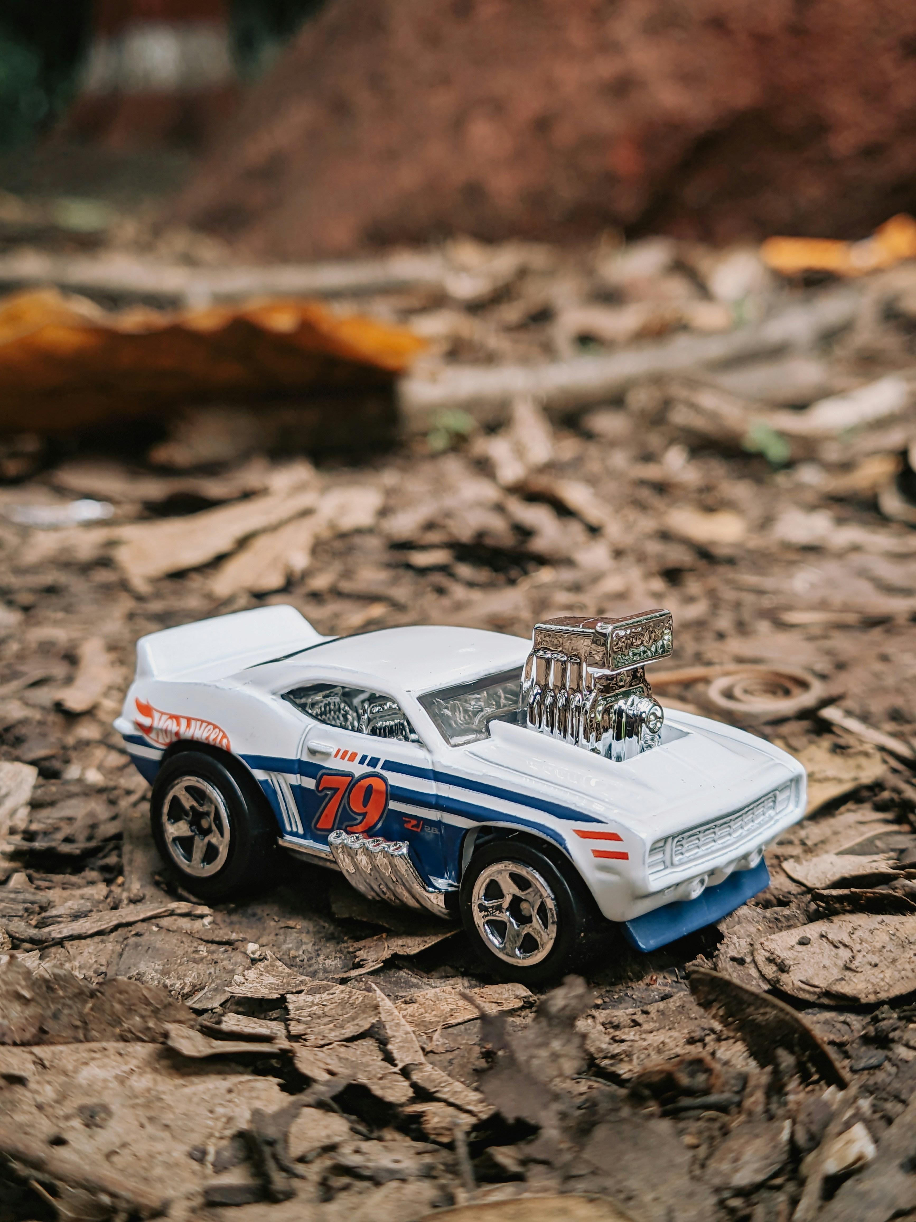 A white toy car rests on the ground.