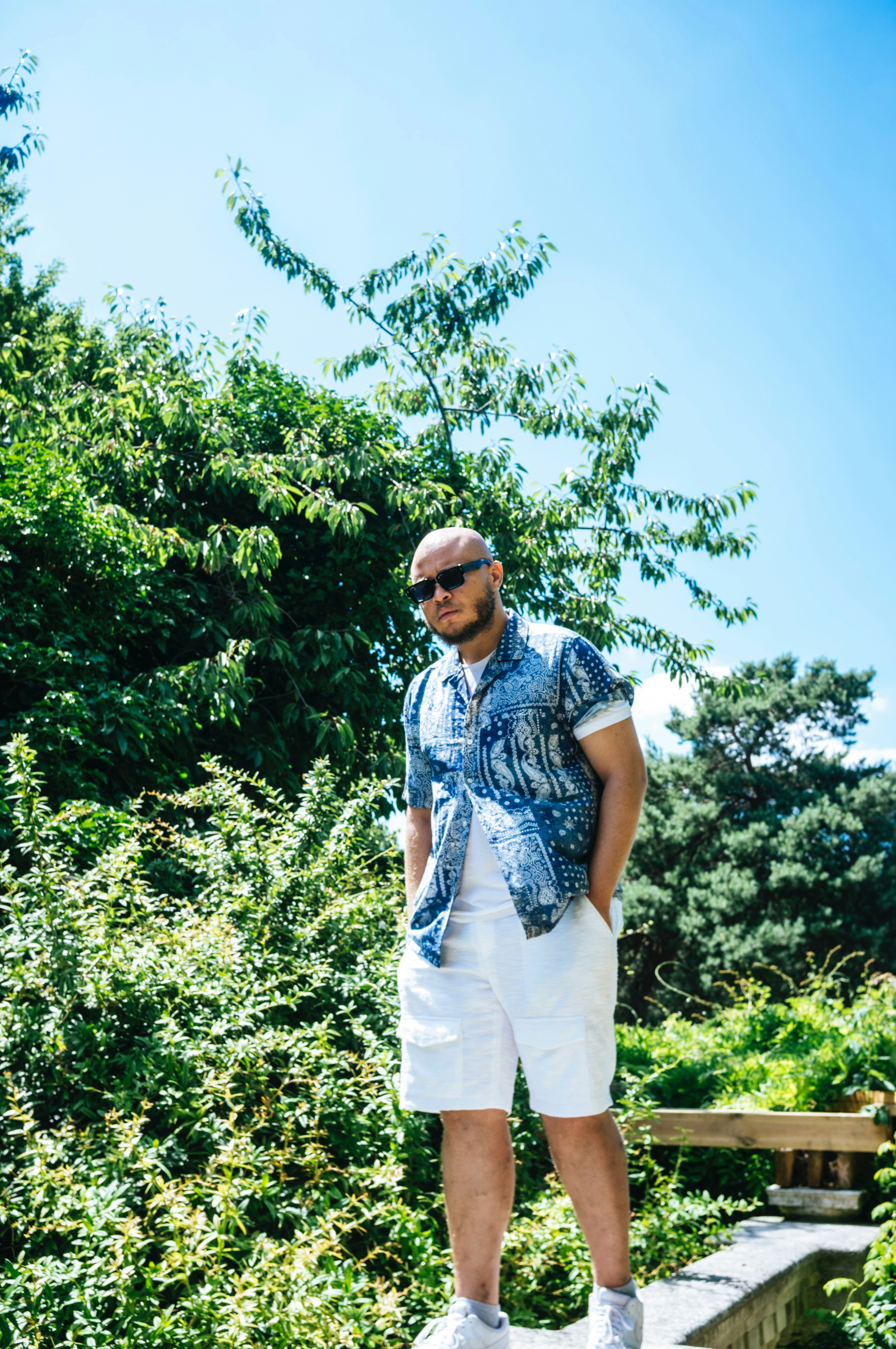 Stylish man poses outdoors on a sunny day.