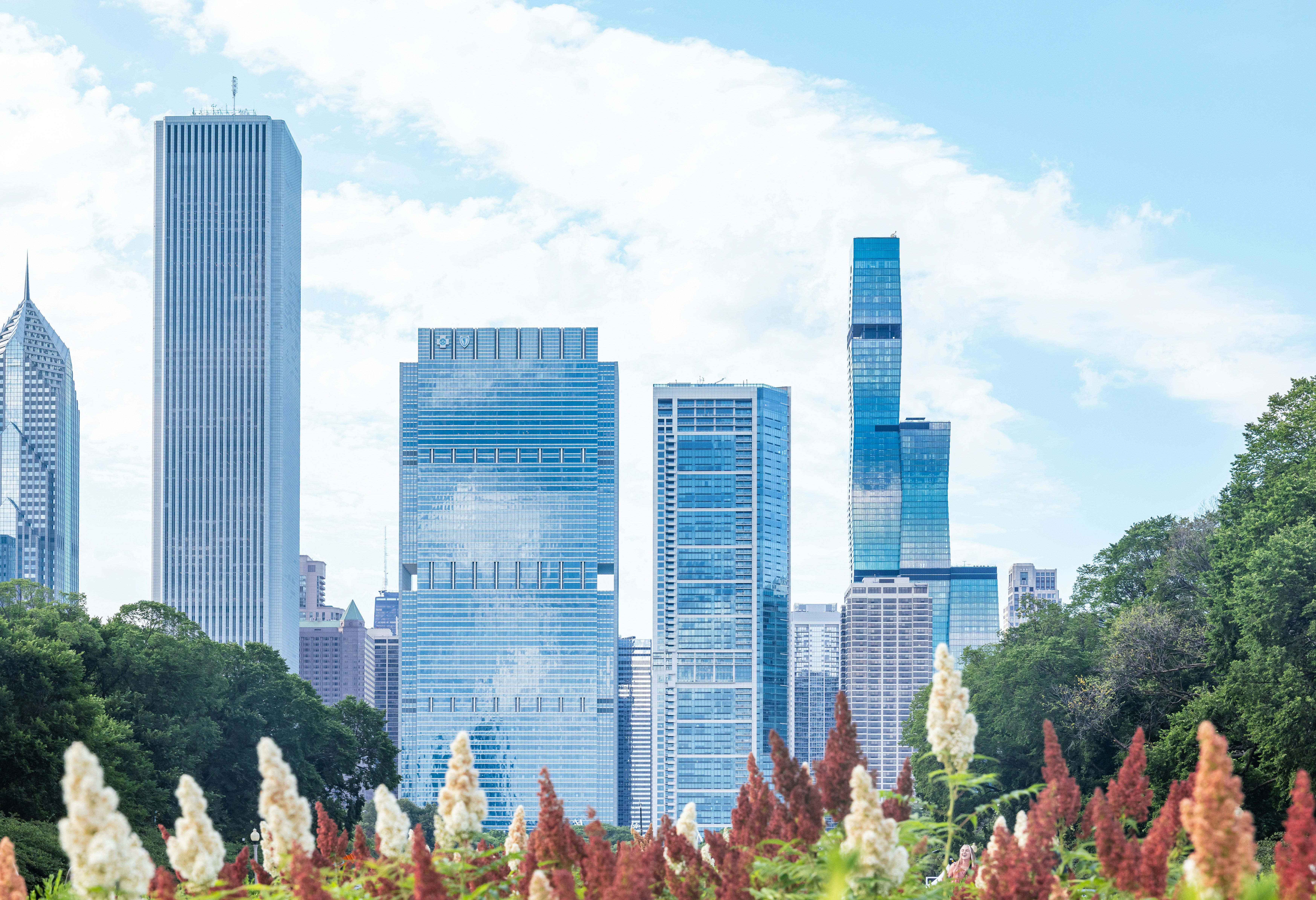 City skyscrapers stand tall against a bright blue sky.