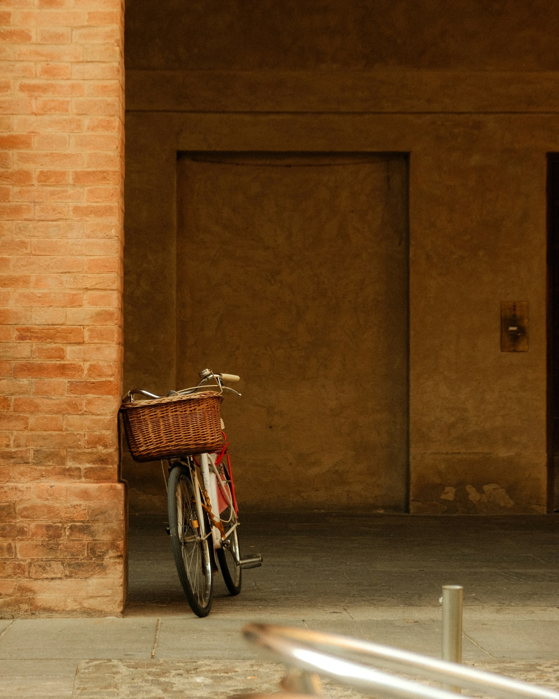 A bicycle rests against a brick wall.