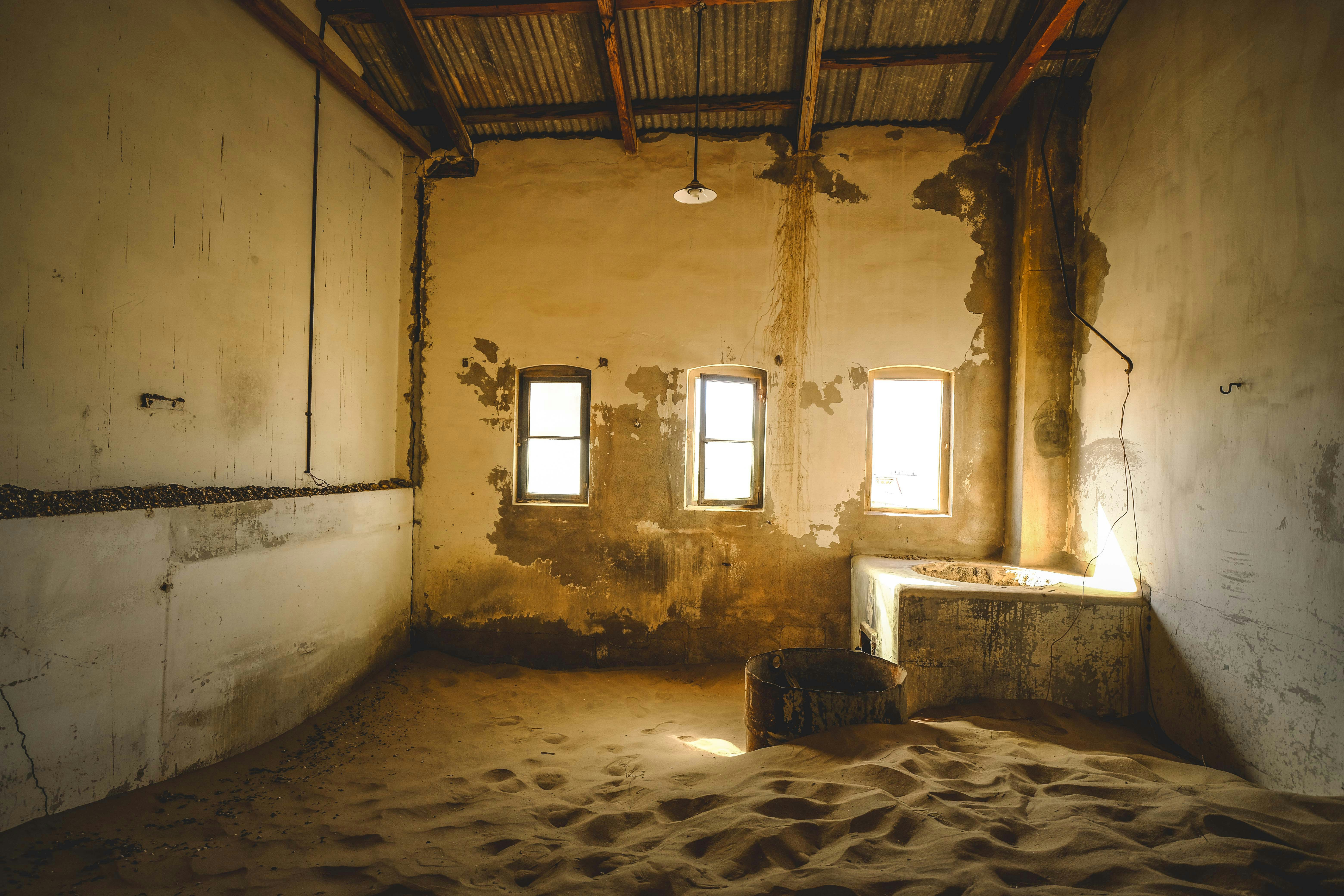 An abandoned room is filled with sand.