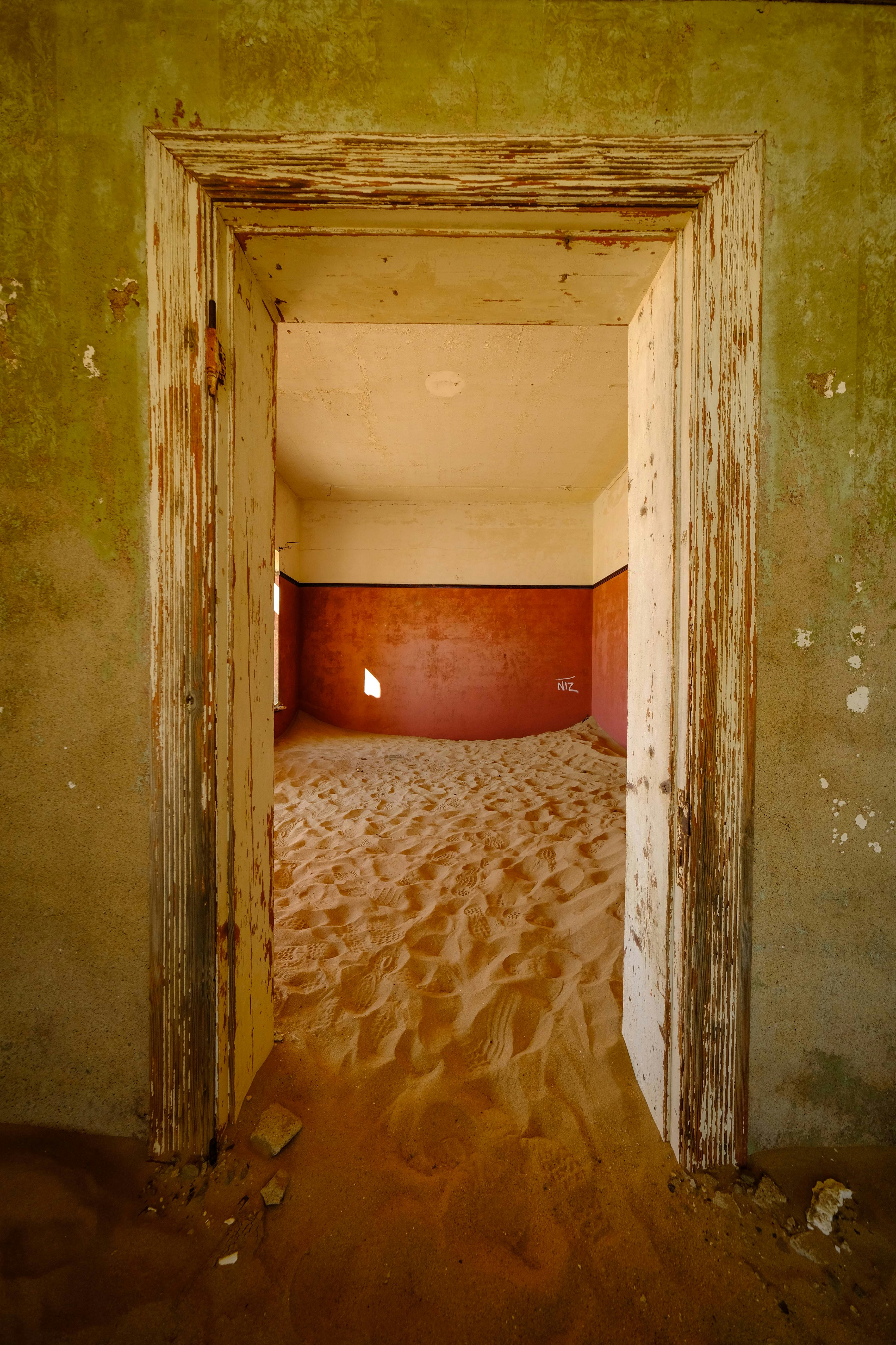 An abandoned room is filled with sand.