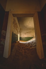 Sand dunes fill an abandoned room's interior.