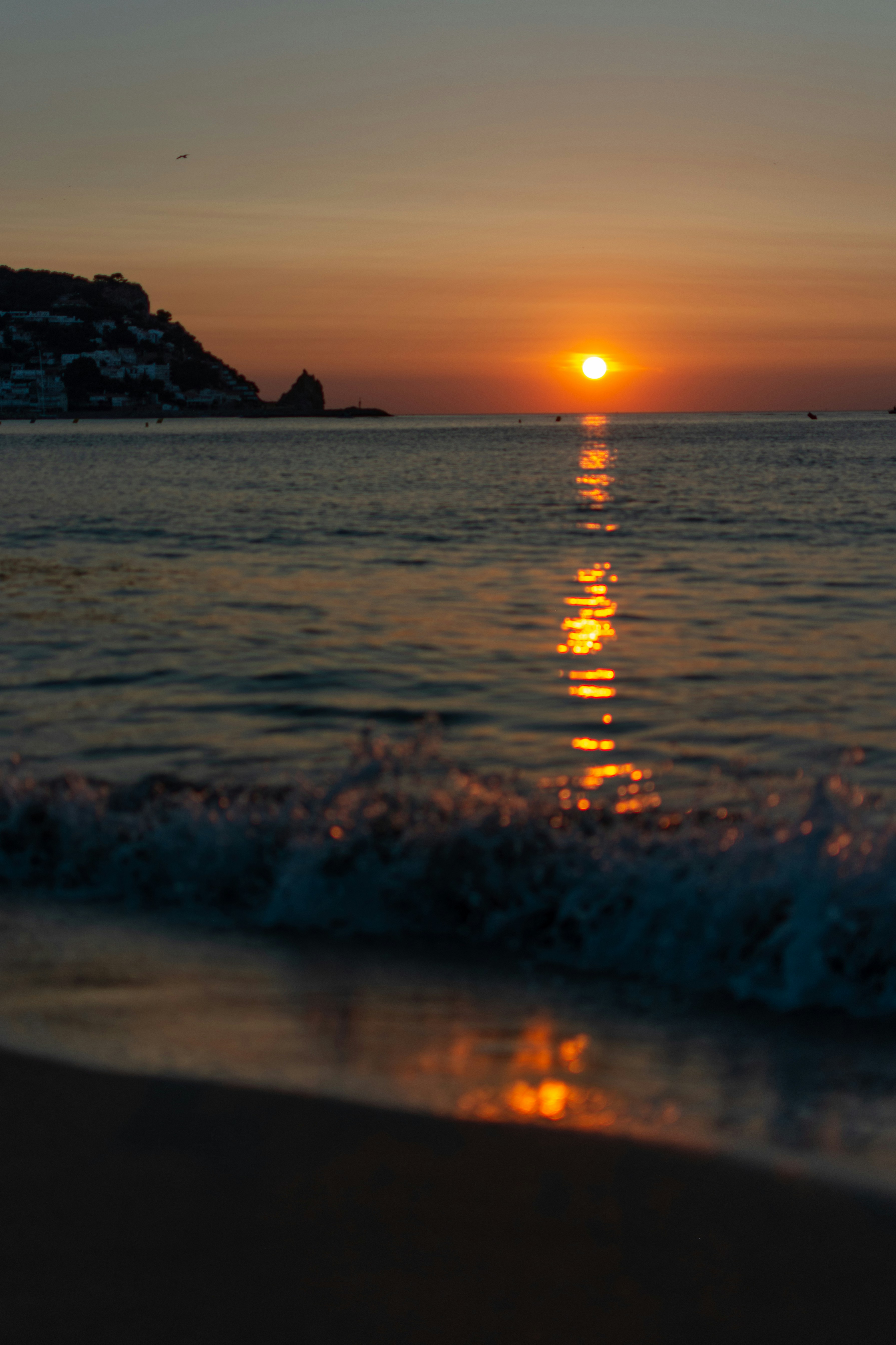 Sunset over the calm ocean reflecting warm light.