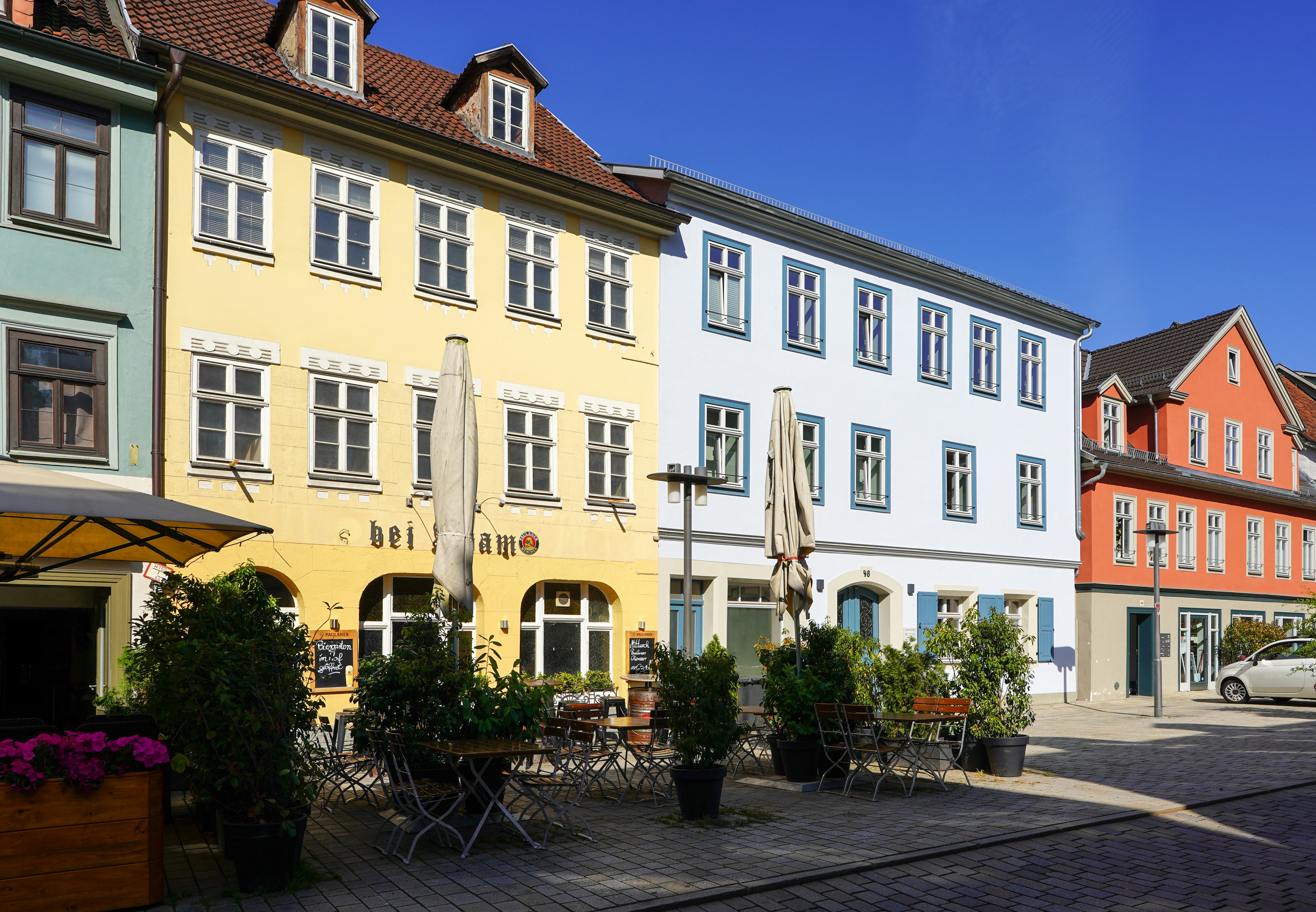 Colorful buildings line a sunny street in europe.
