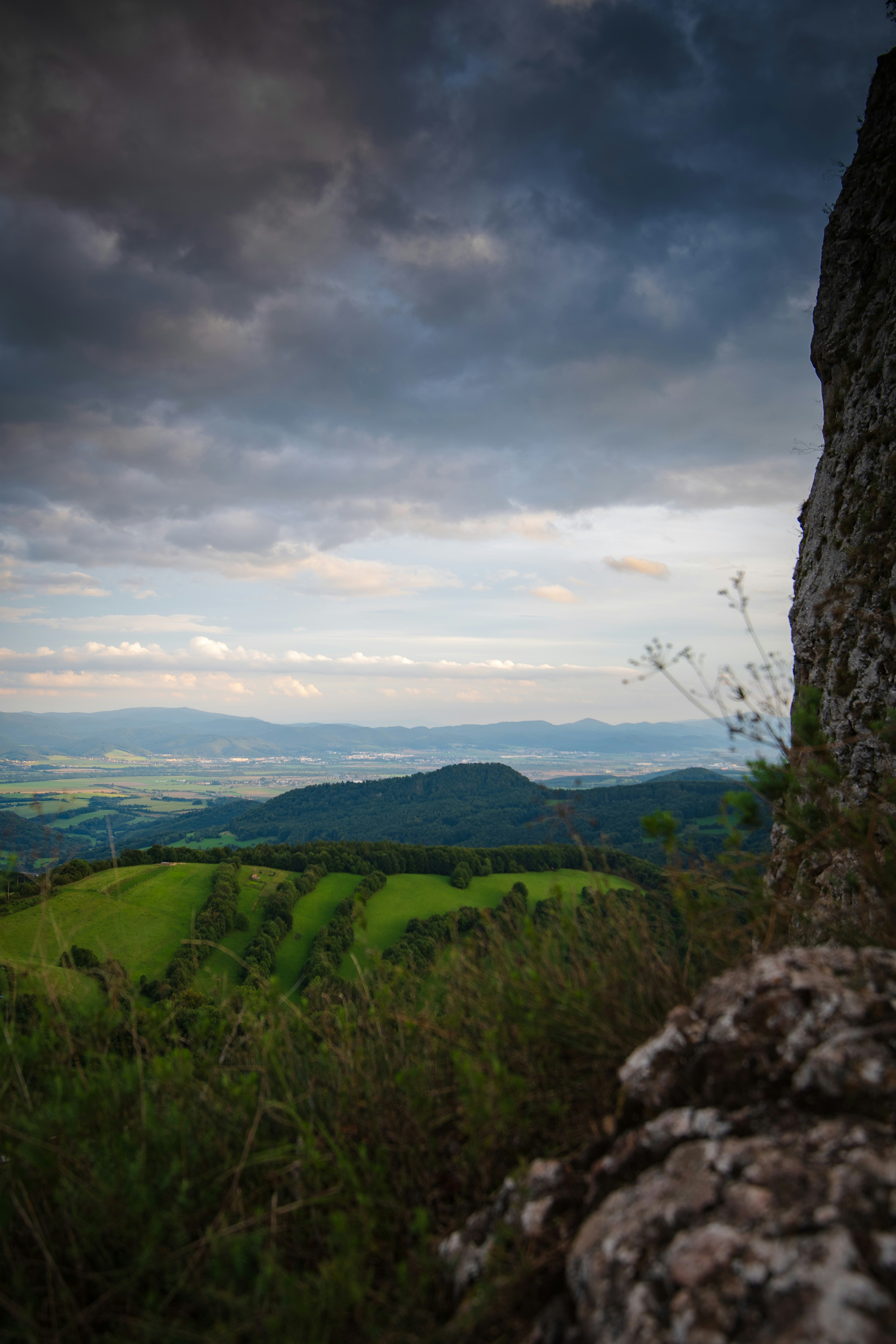 Overlooking a green landscape beneath a stormy sky.