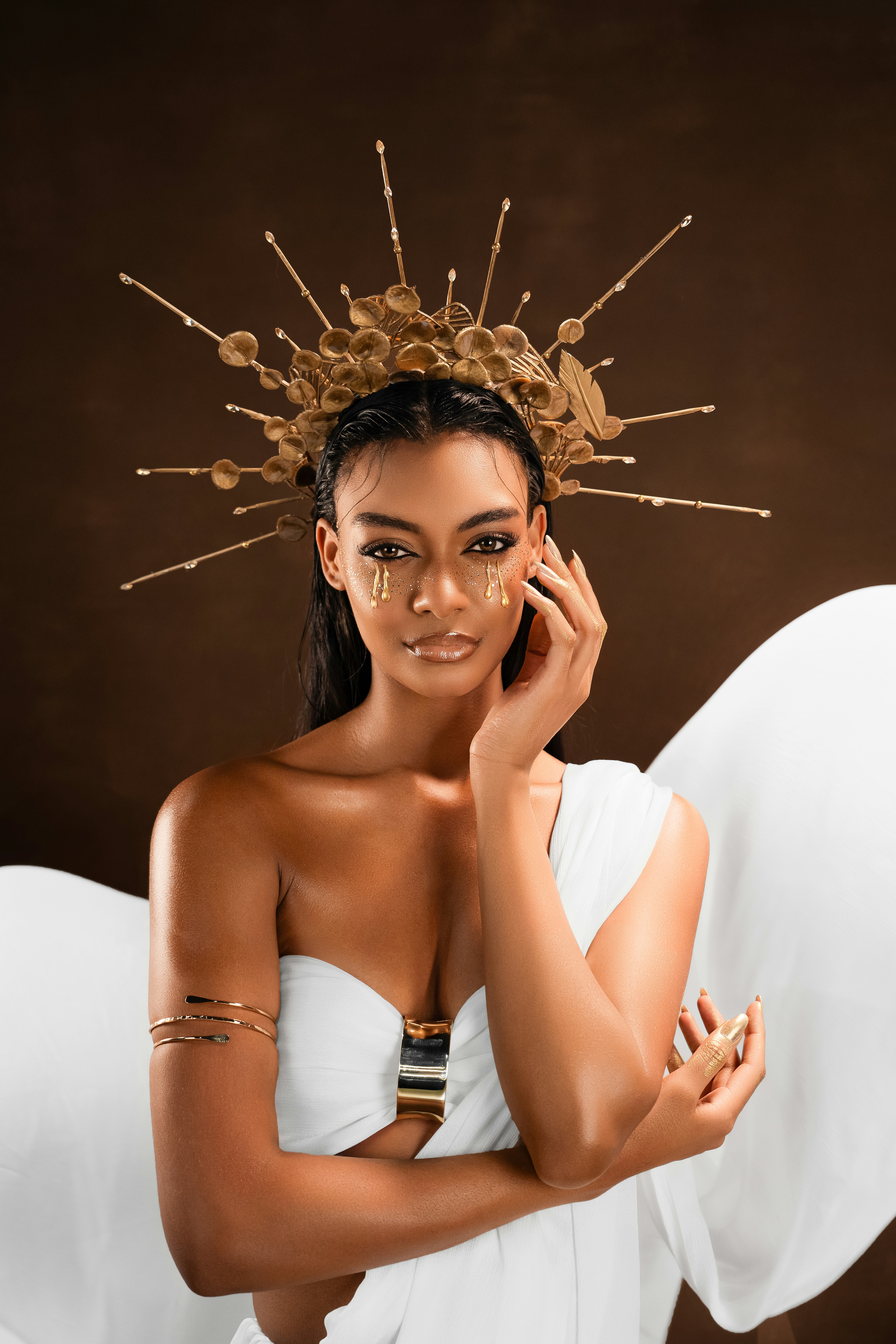 Eine Frau mit goldenem Kopfschmuck und weißem Kleid.