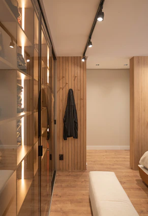 A modern walk-in closet with warm lighting.