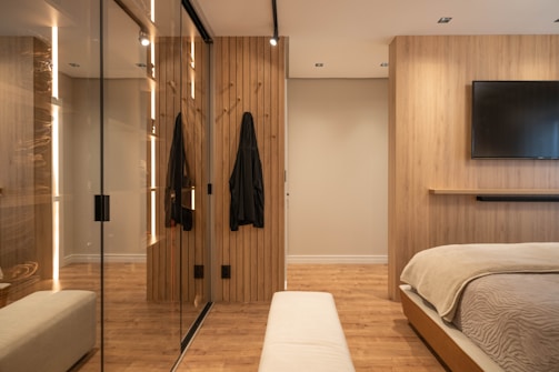 A modern bedroom with wood and a mirrored closet.