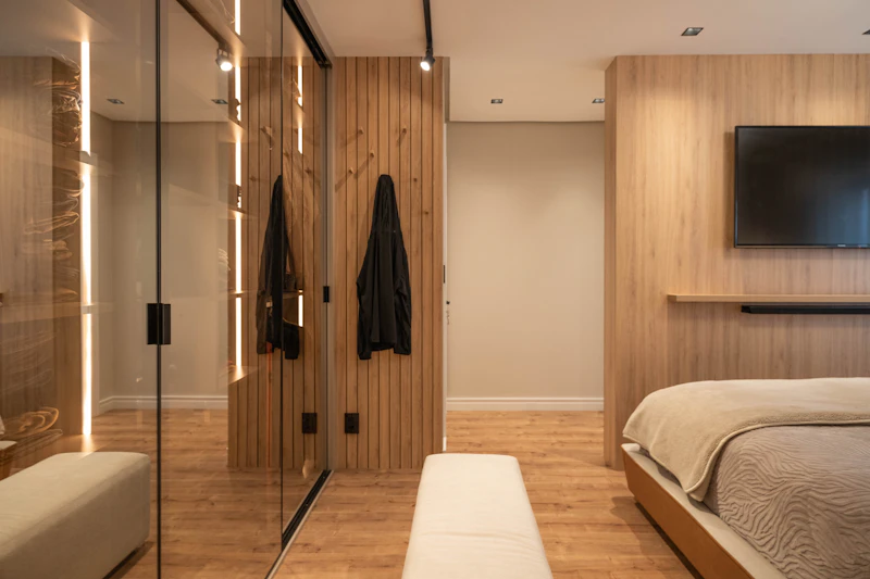 Modern bedroom with wood-finish wardrobes and mirrored doors