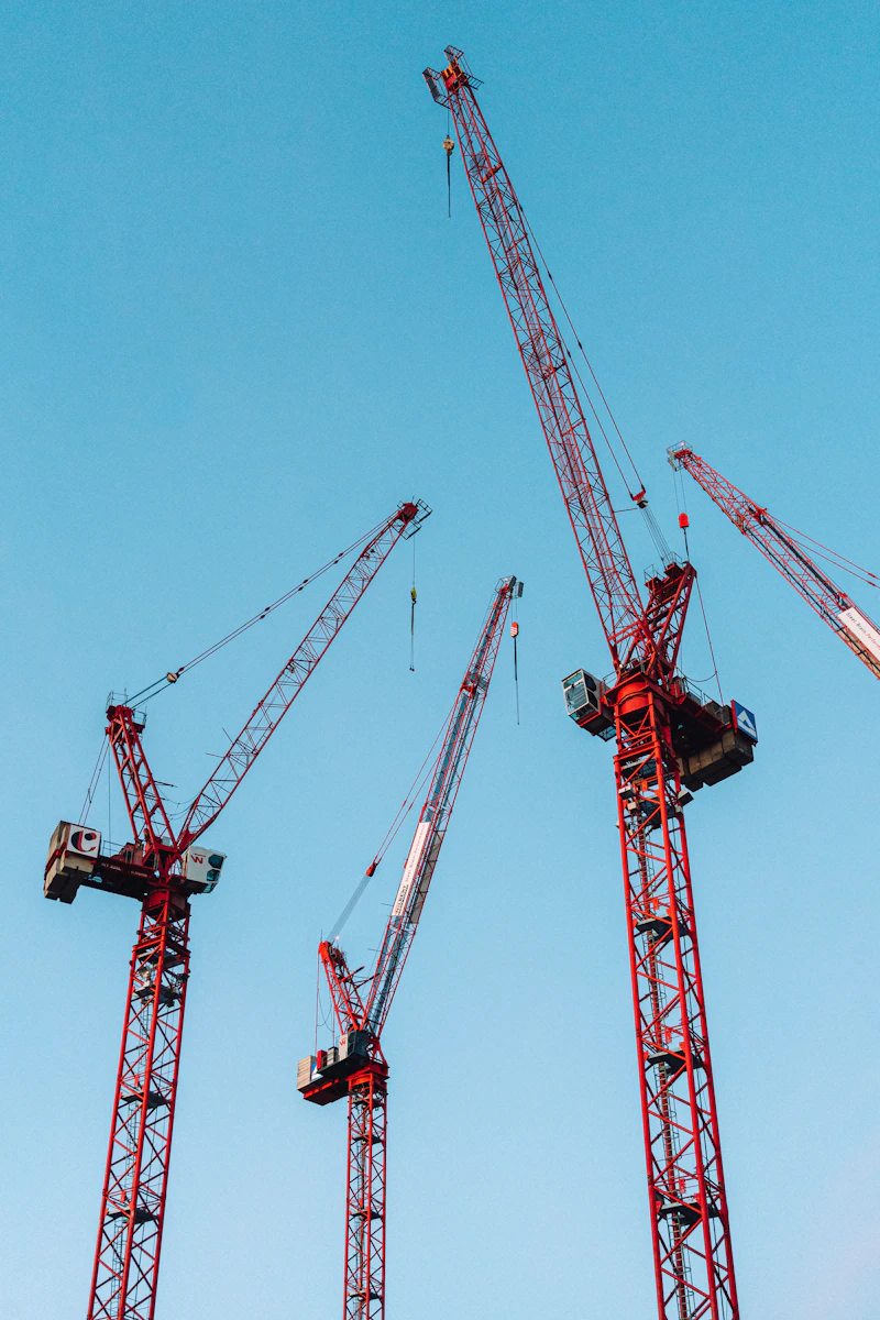 Construction cranes against blue sky