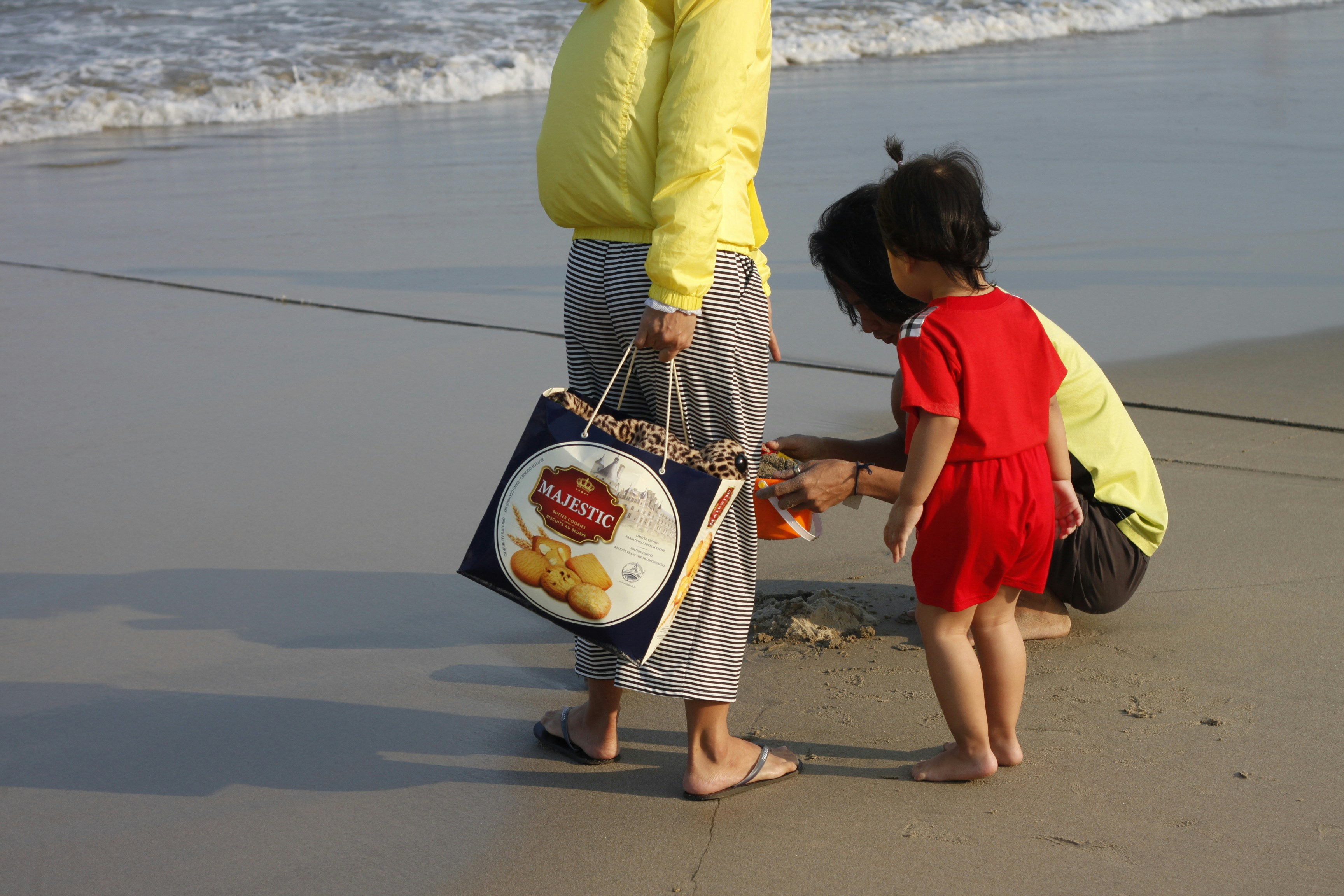 parent and toddler playing on a beach - where to travel with kids
