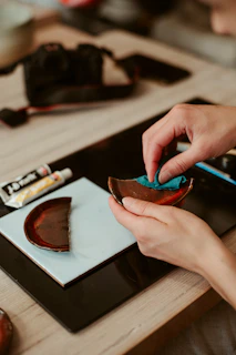 Repairing a broken ceramic bowl with glue and a cloth.