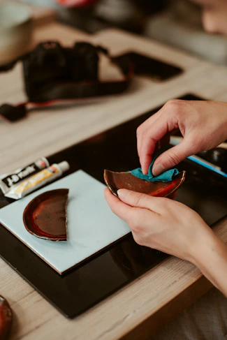 Repairing a broken ceramic bowl with glue and a cloth.