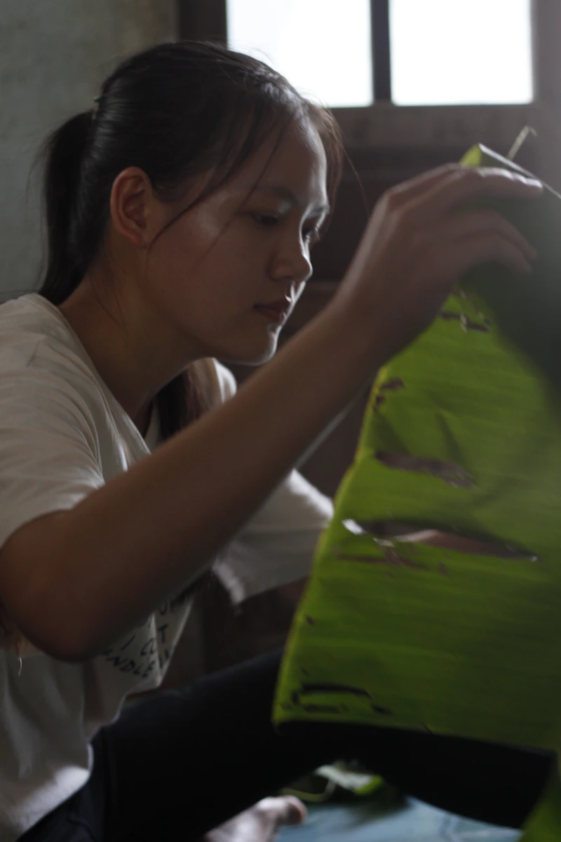Woman carefully arranging a green leaf.