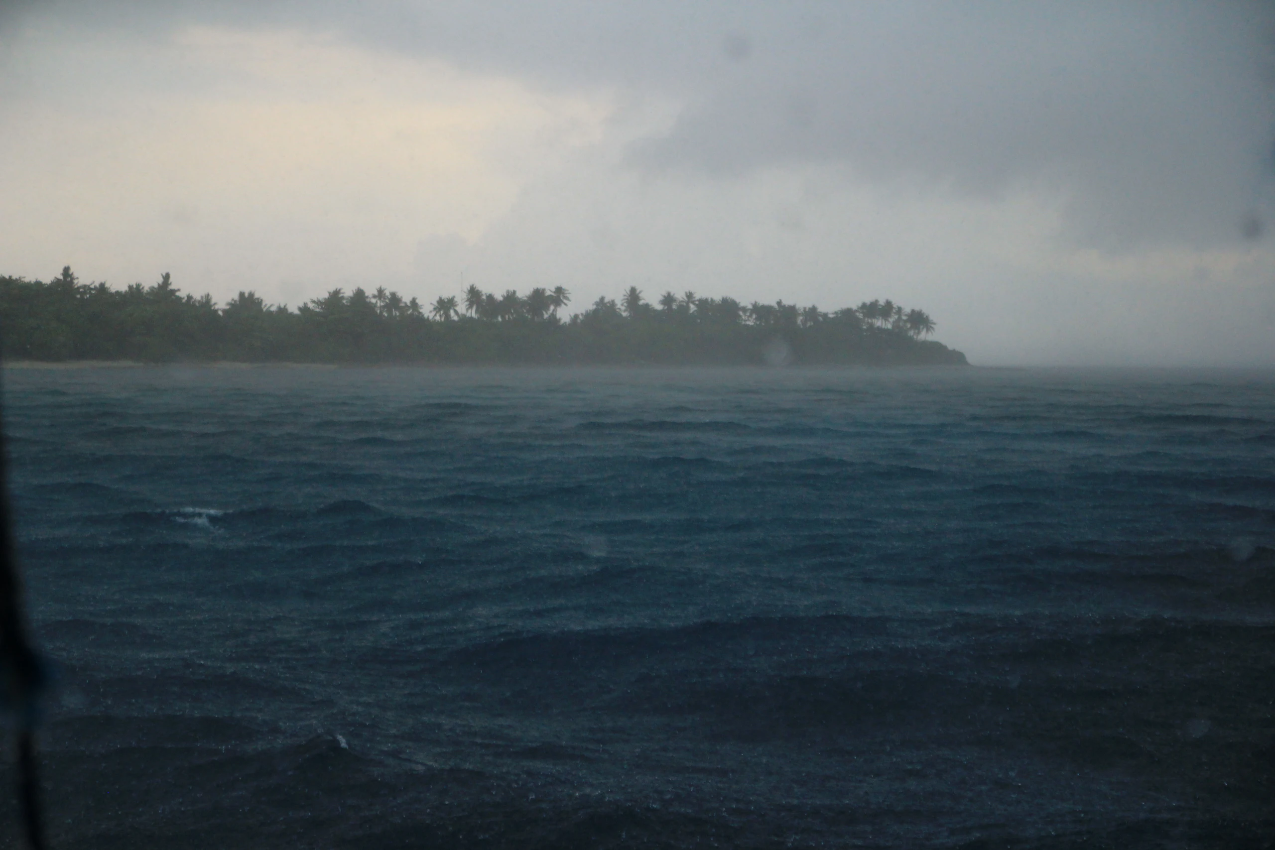 Afternoon storm clouds gathering over a green island coastline