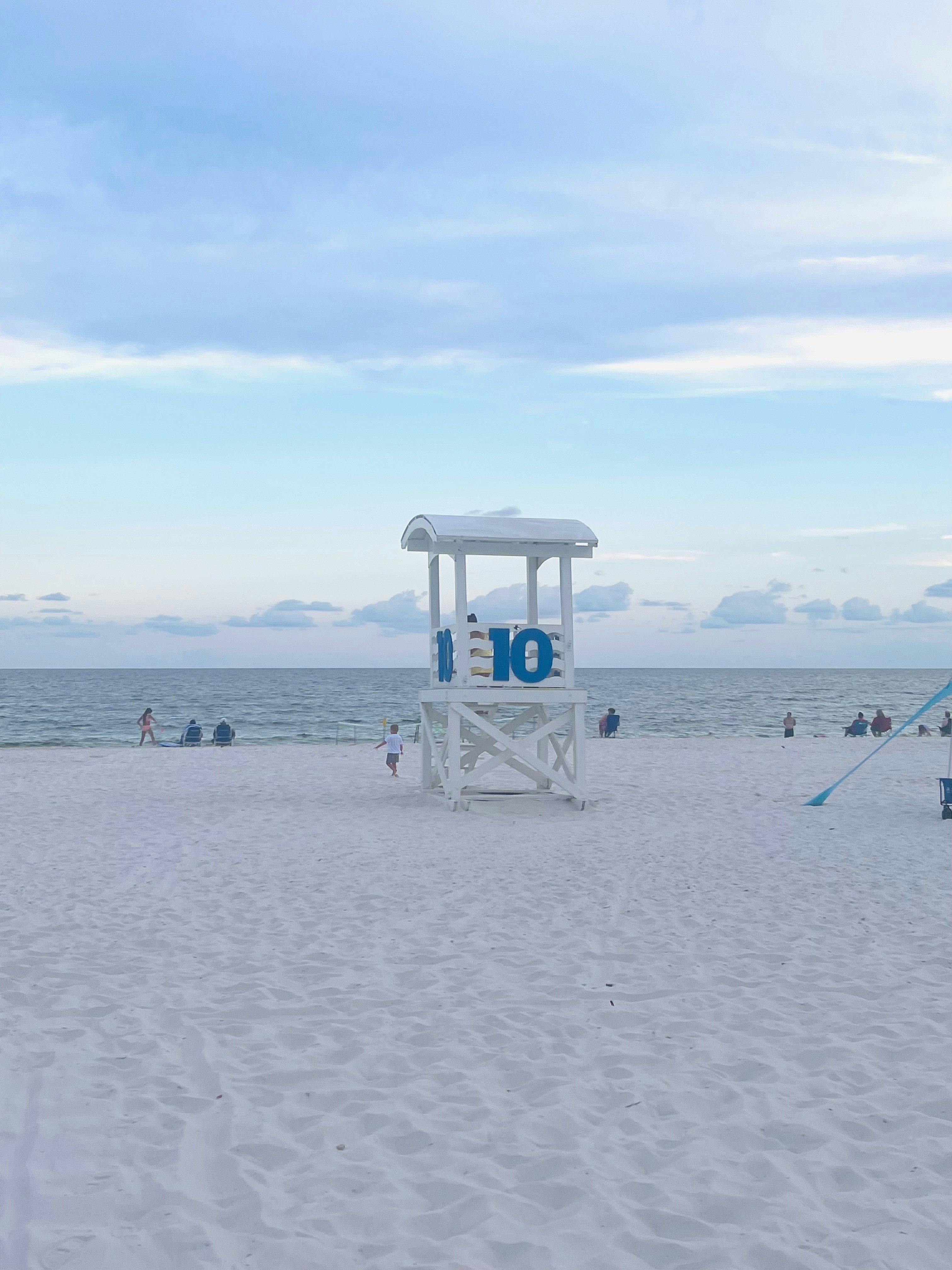 A lifeguard stand sits on a sandy beach.