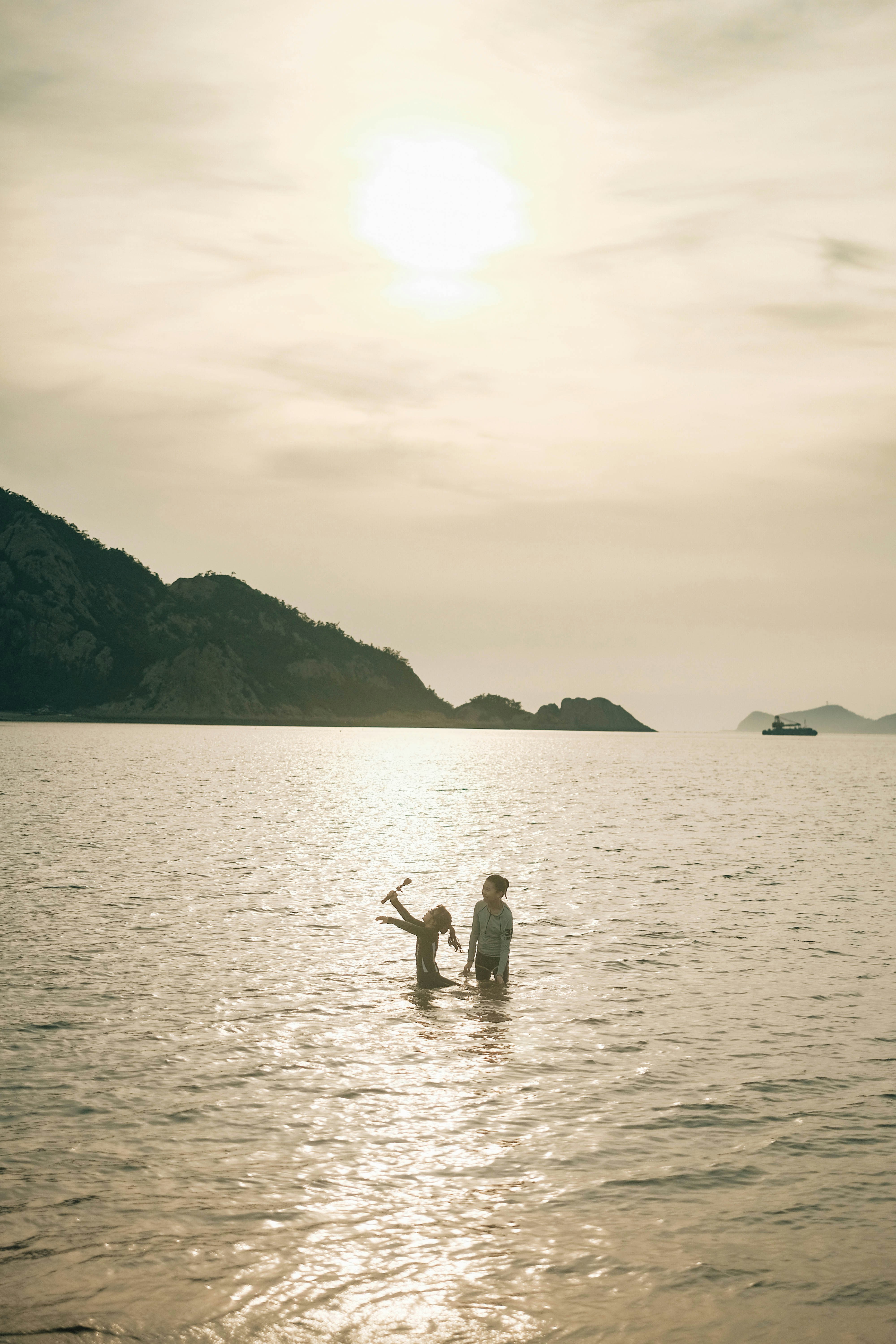 Zwei Menschen spielen bei Sonnenuntergang im Meer.
