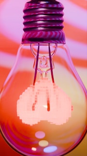 A glowing light bulb with pixelated elements.