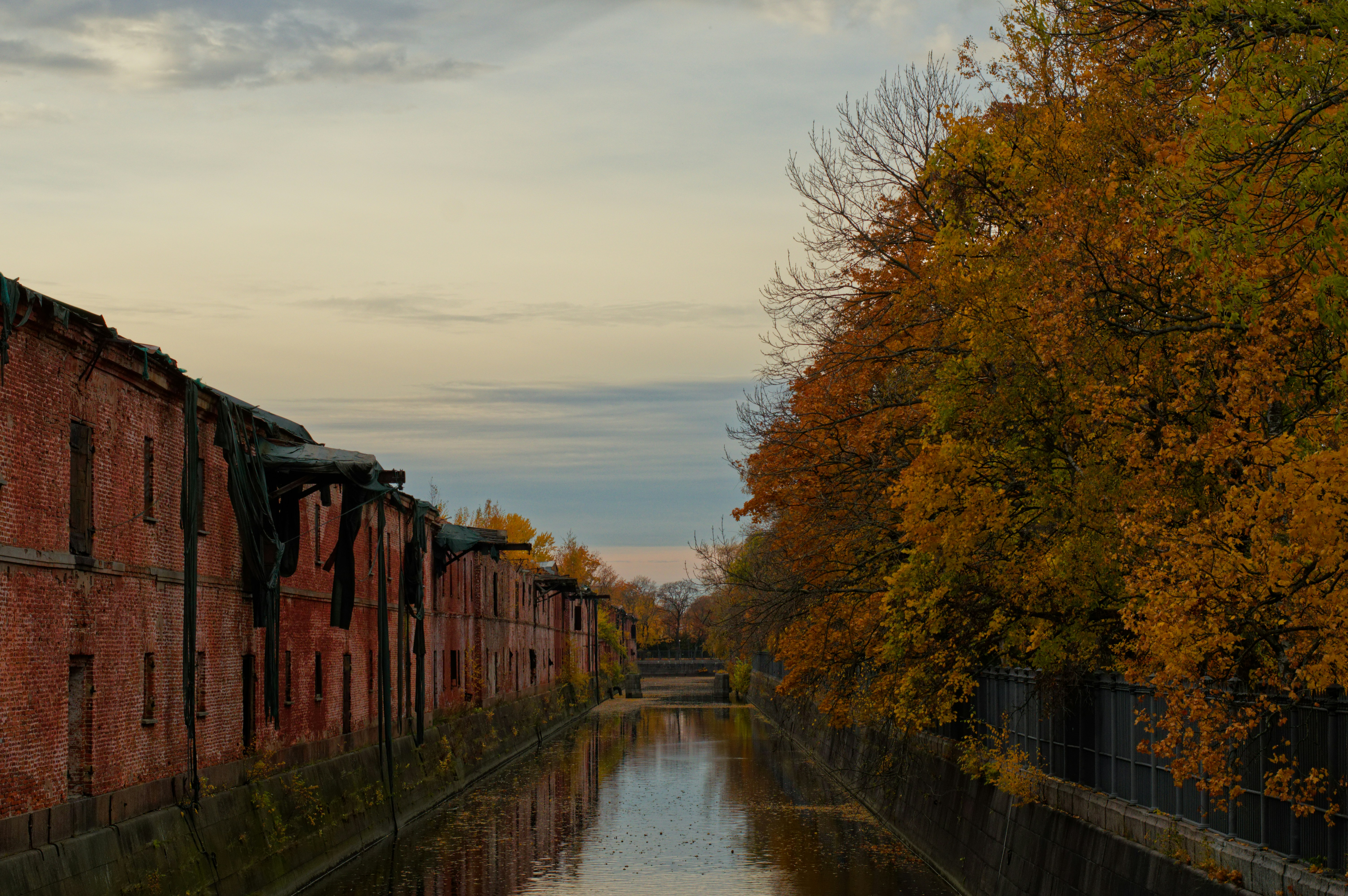 Un canale corre tra vecchi edifici in mattoni e alberi.