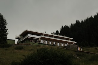 A modern building is on a green hillside.