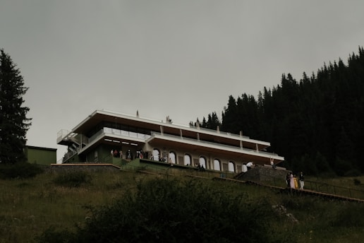 A modern building is on a green hillside.