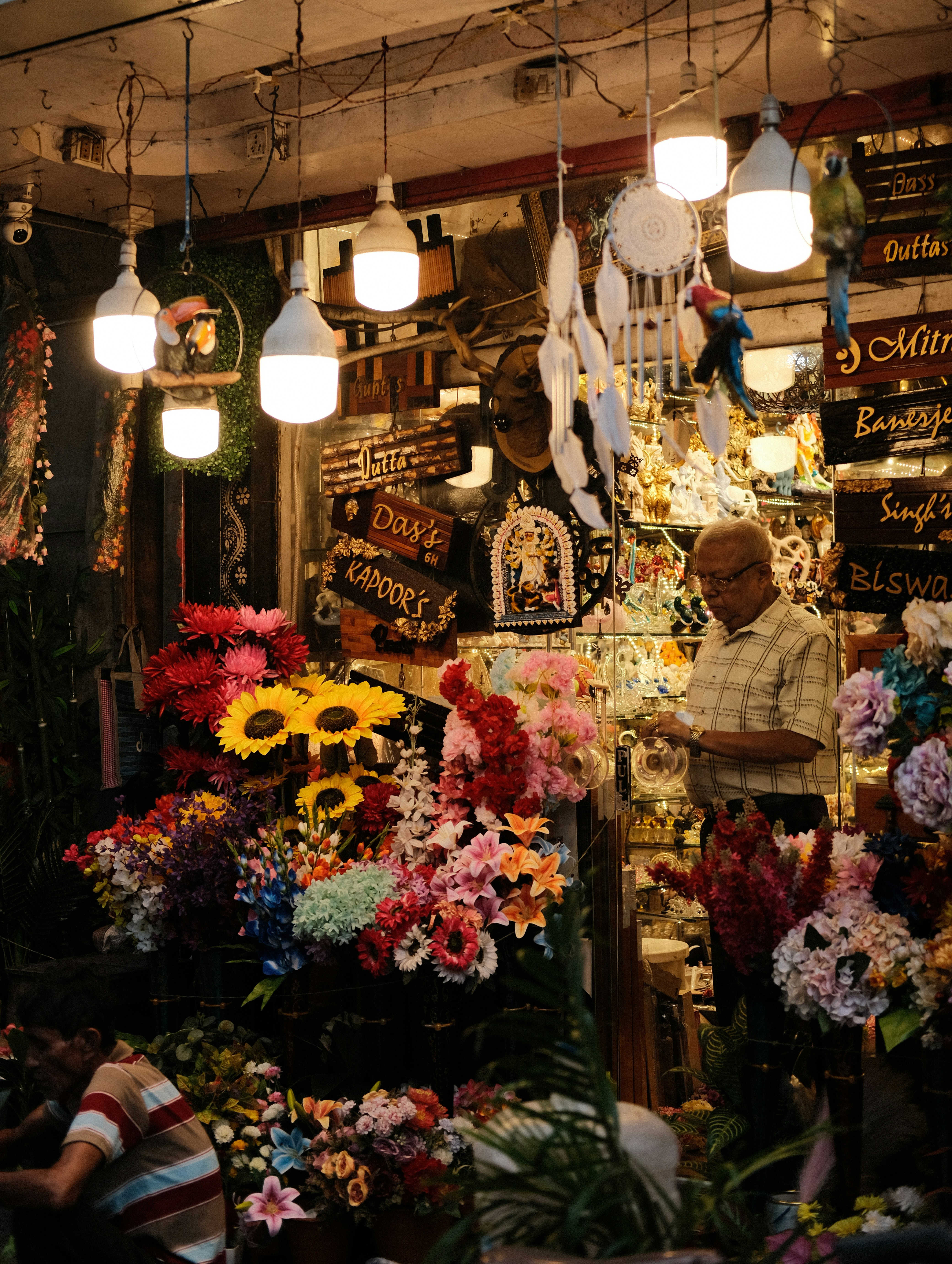 A man works at a colorful flower shop.
