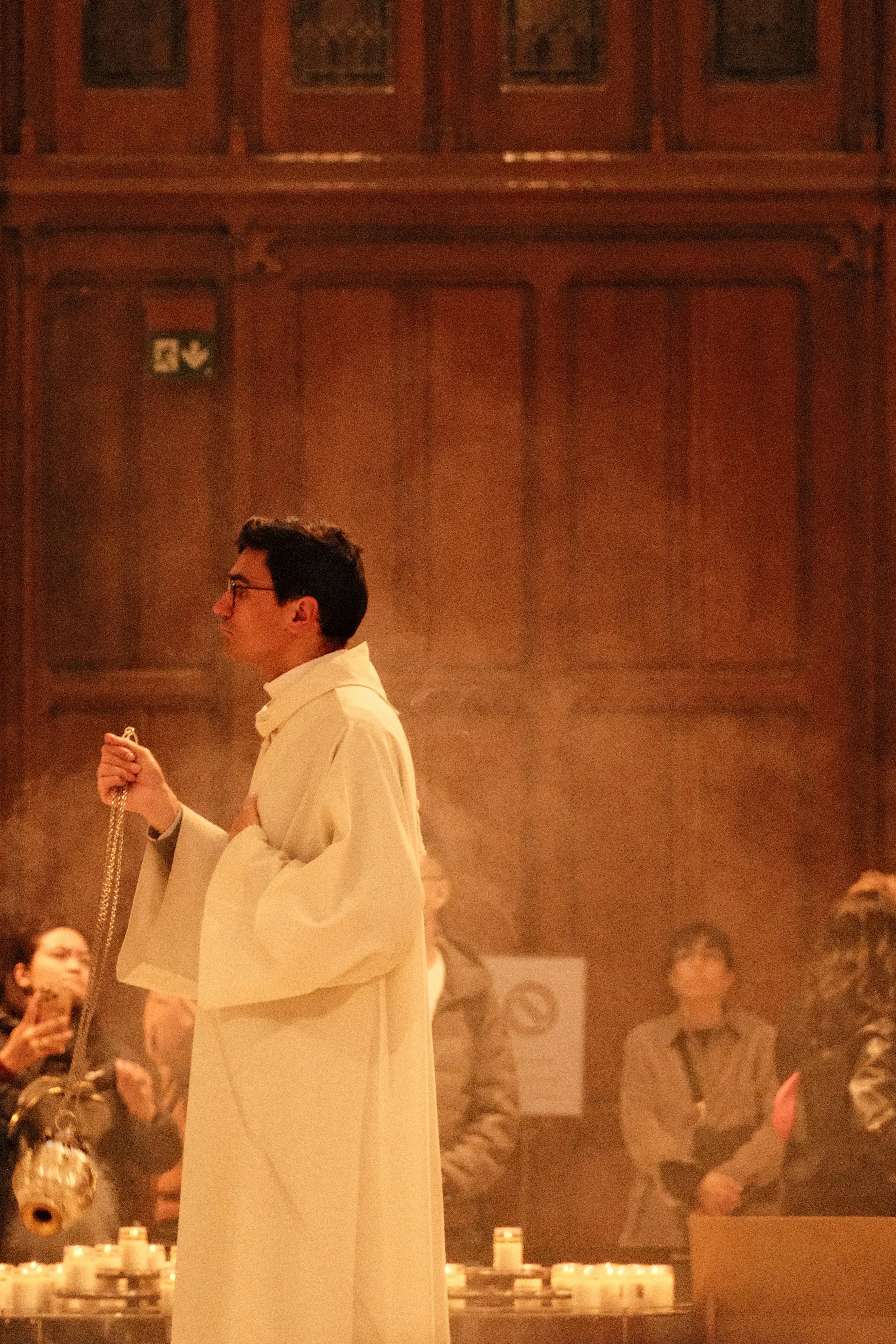 A priest censes incense in a church.