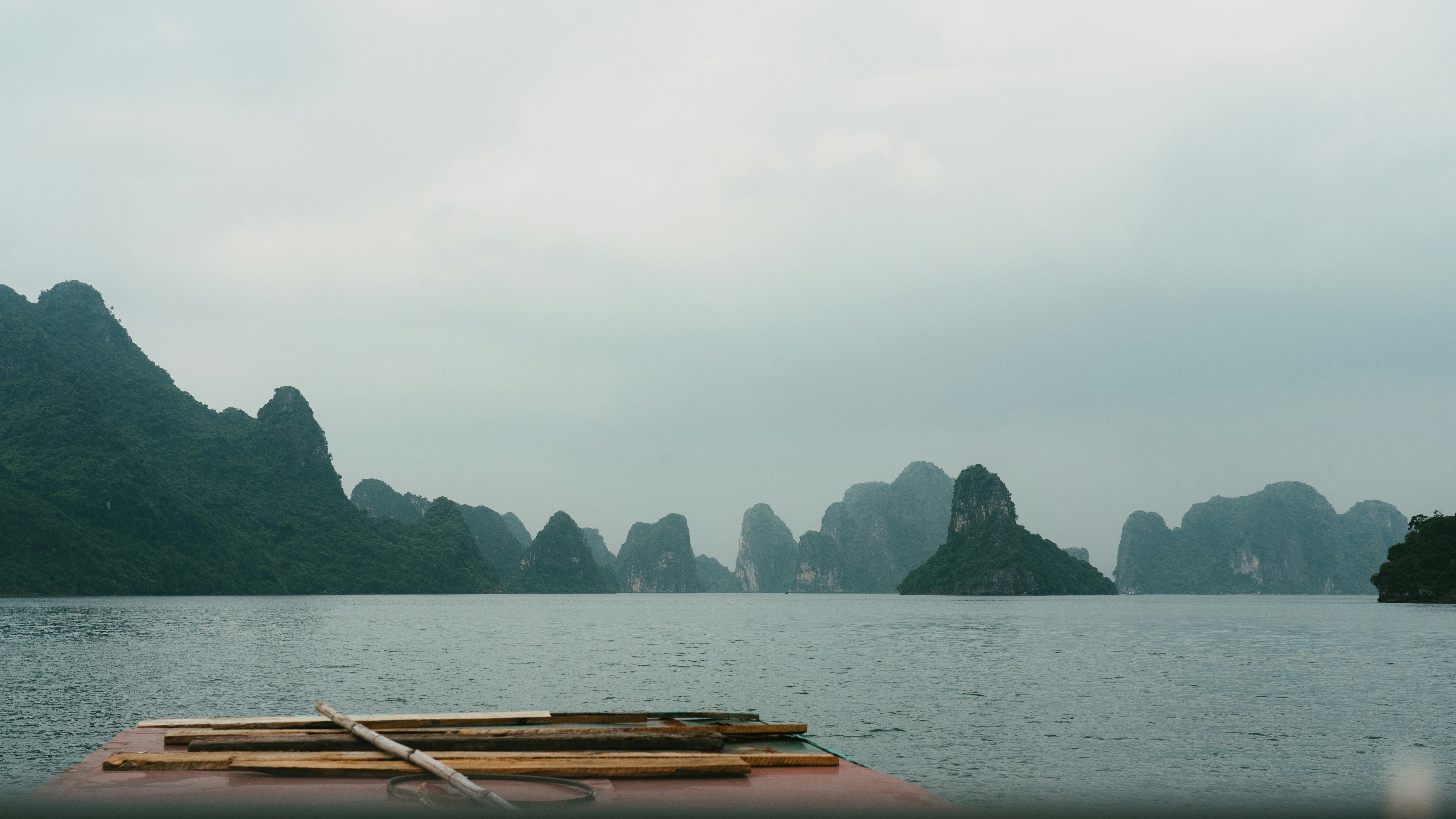 Mountains rise from the sea under a cloudy sky.