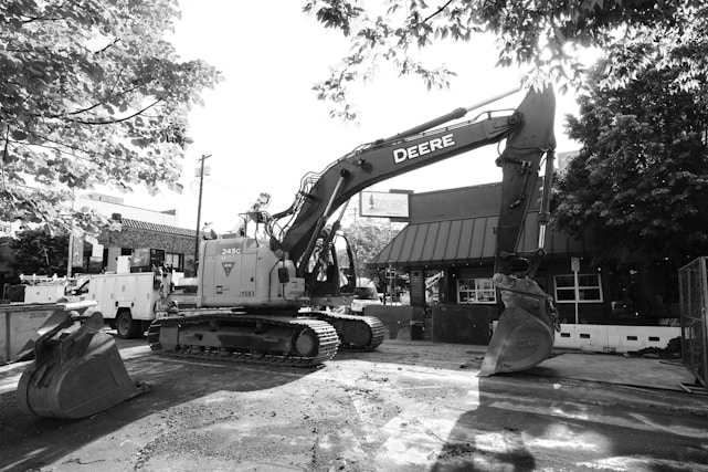 A john deere excavator in front of a building.